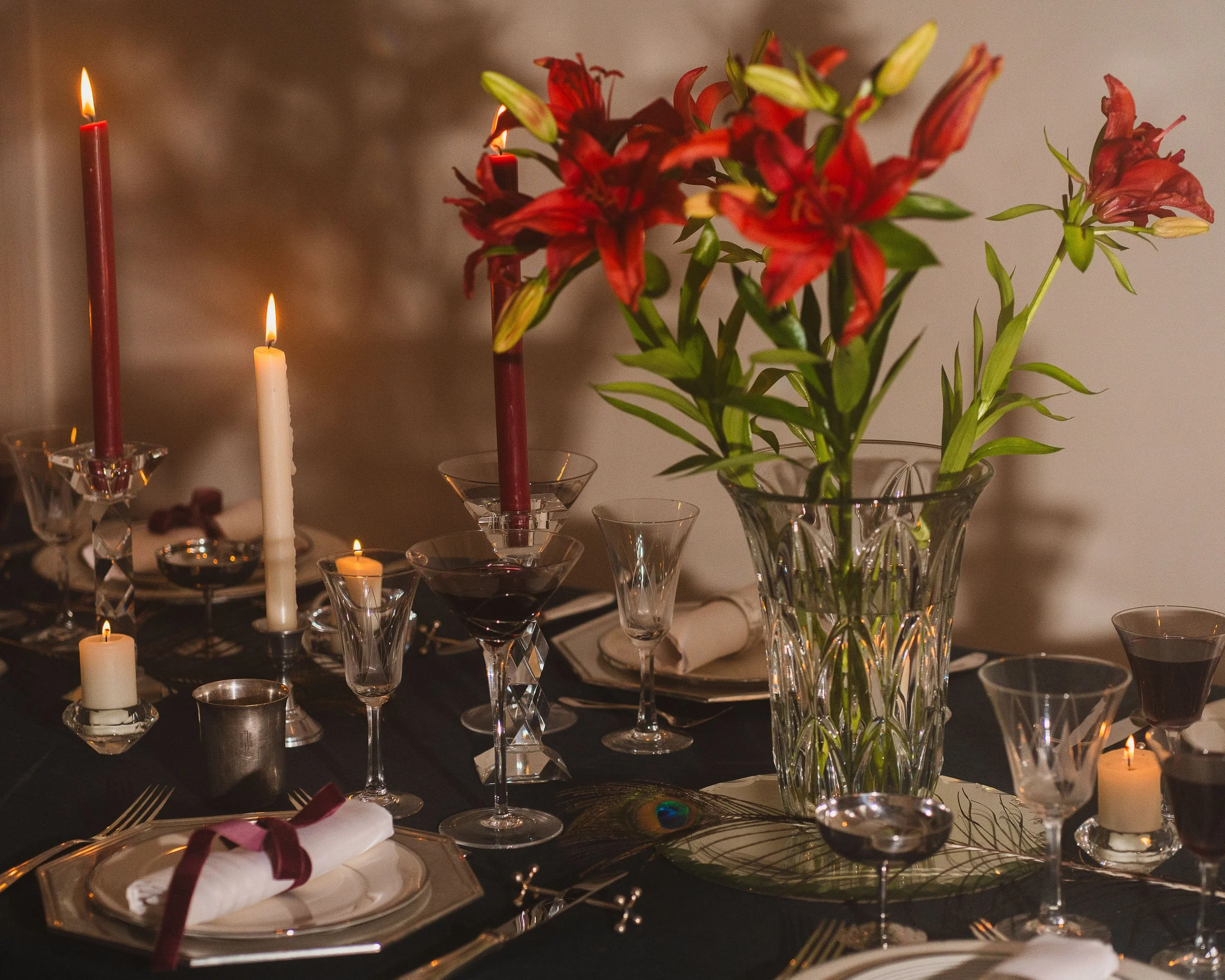 Ambiance festive, table de fête, fleurs rouges, argenterie, verres cristal, porcelaine, porte-couteaux Christofle