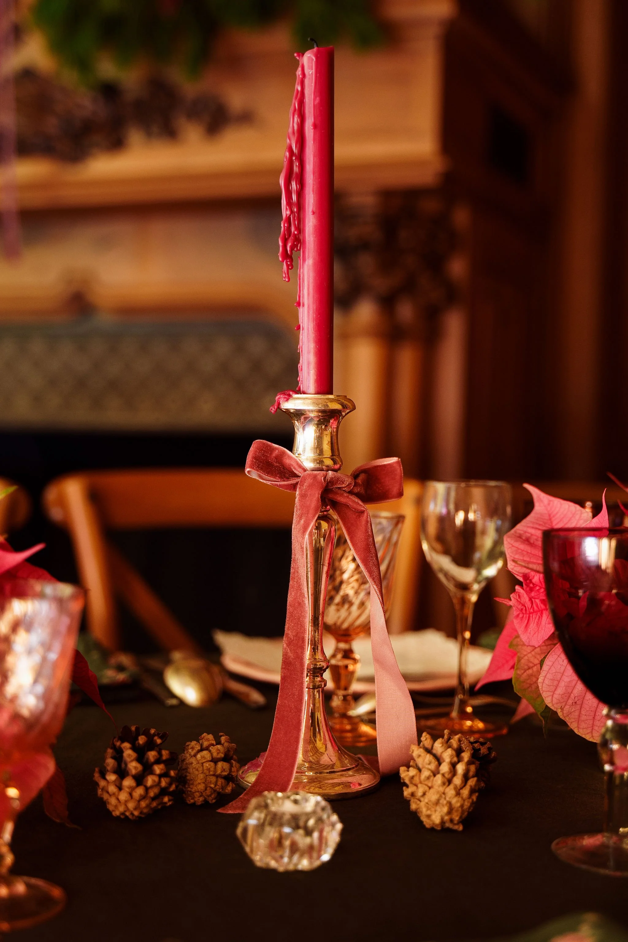 Chandelier argenté, bougie bordeaux, nœud en velours, pommes de pin