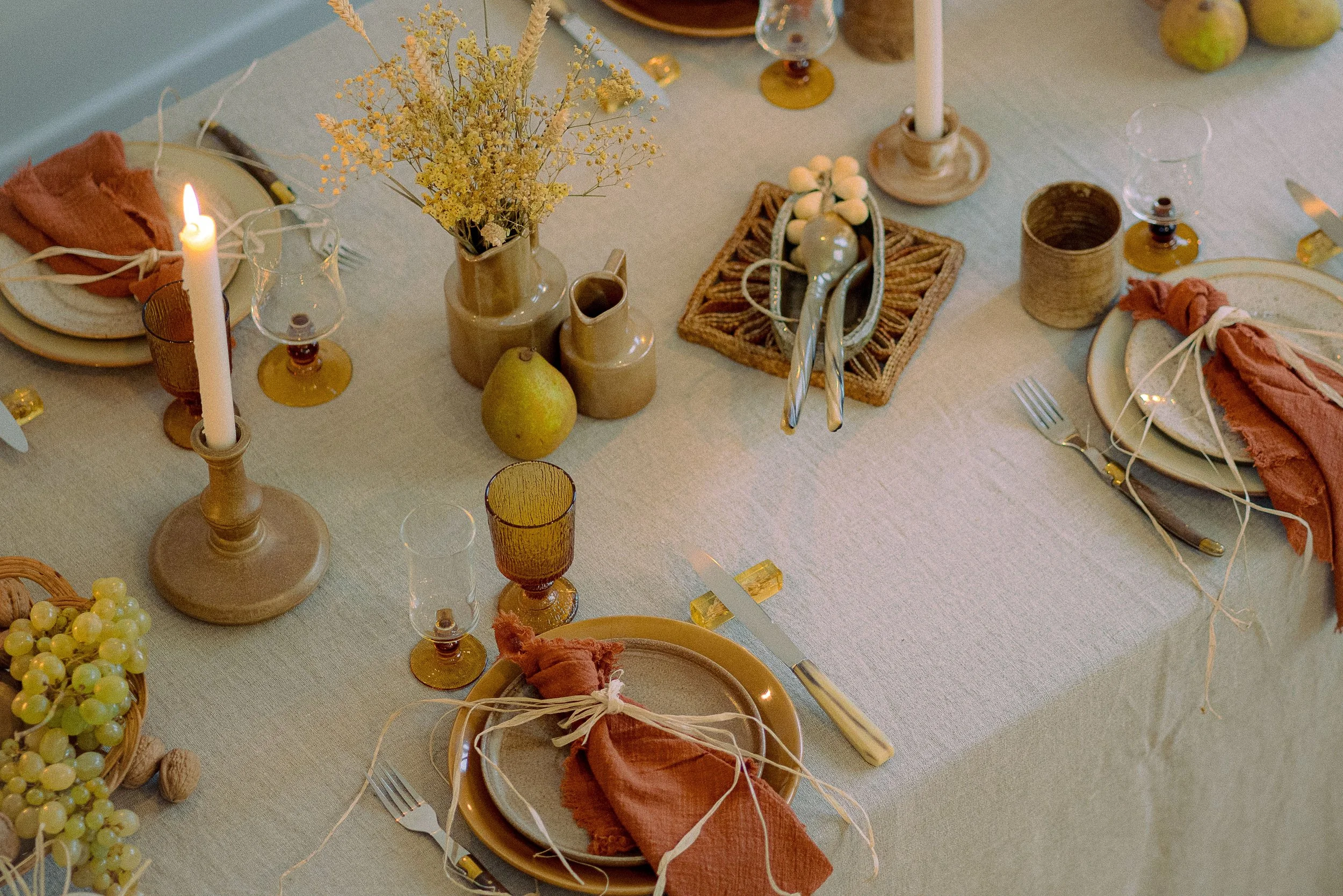Mise en scène naturelle, couleurs beige & terracotta, matières lins, grès, osier, vaisselle, couverts, verres ambrés, vases, bougeoirs