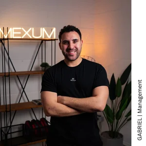 Gabriel, Management im Motus Sportstudio, im Studio vor einer beleuchteten MEXUM-Schrift