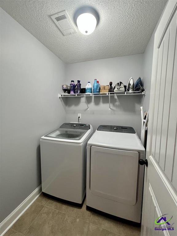 Laundry room with washer, dryer, shelf with cleaning supplies and ironing equipment.