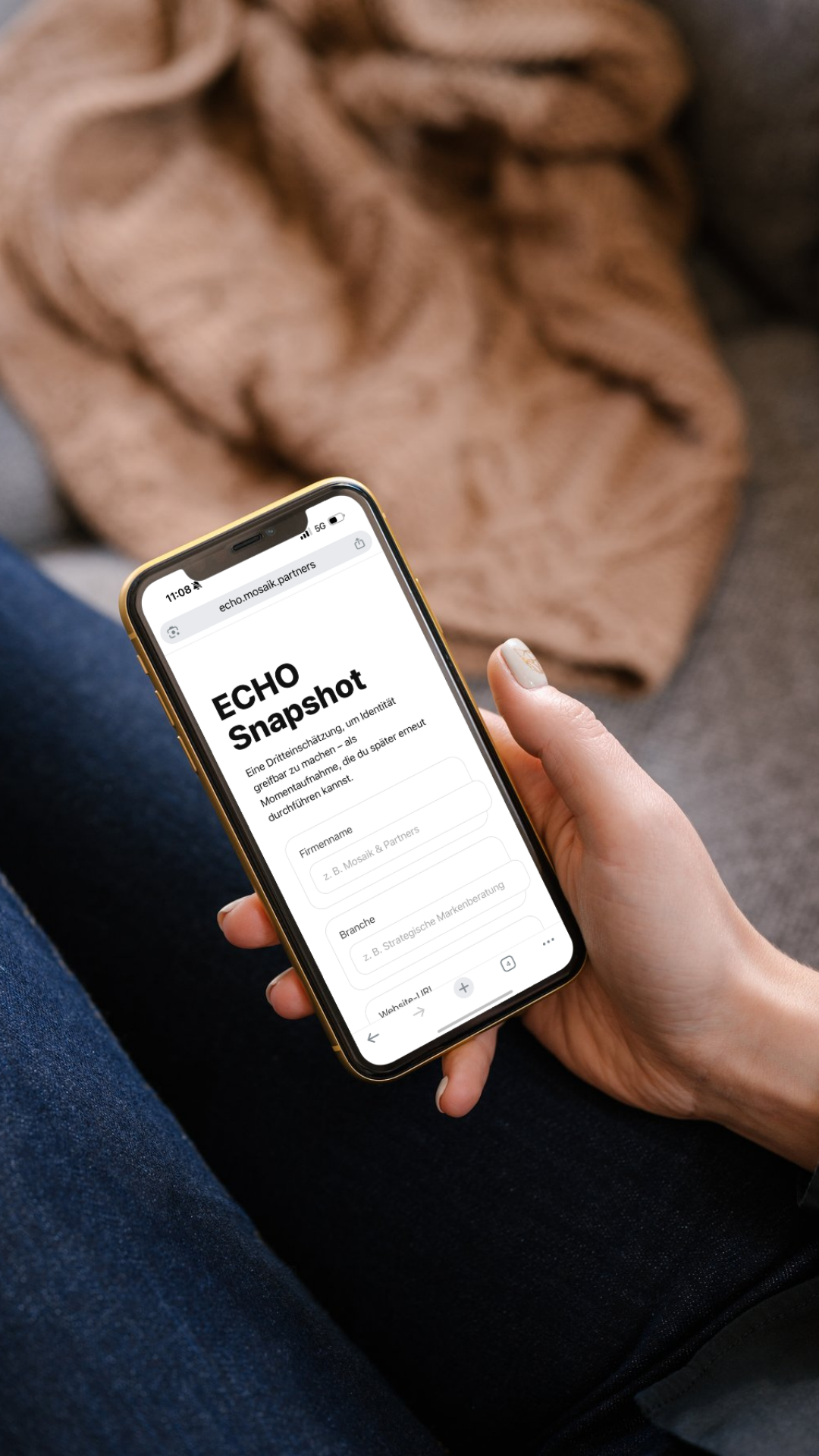 Nahaufnahme einer Person, die ein Smartphone hält und auf einer Webseite namens "ECHO Snapshot" surft, während sie auf einem Sofa sitzt.