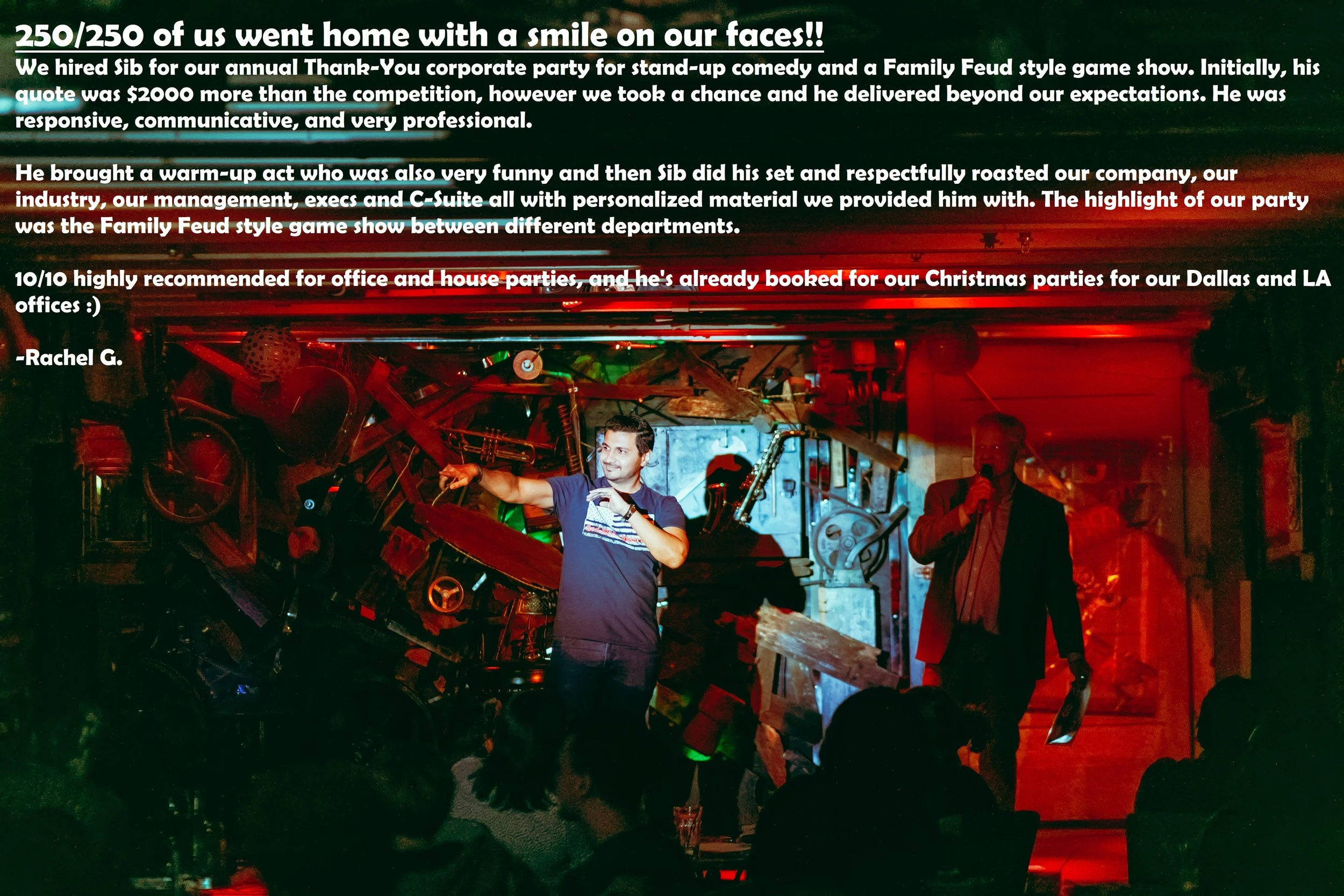 A lively indoor event with people on stage, one man holding a microphone, and another man smiling and gesturing. The background features various machinery and decorations, with red and green lighting creating a festive atmosphere.