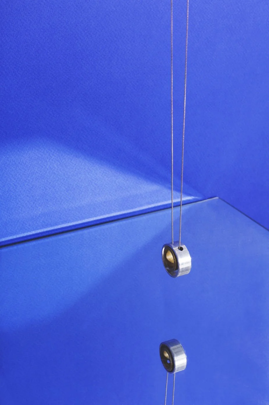 modern-jewelry-hanging-on-blue-with-reflection.jpg
