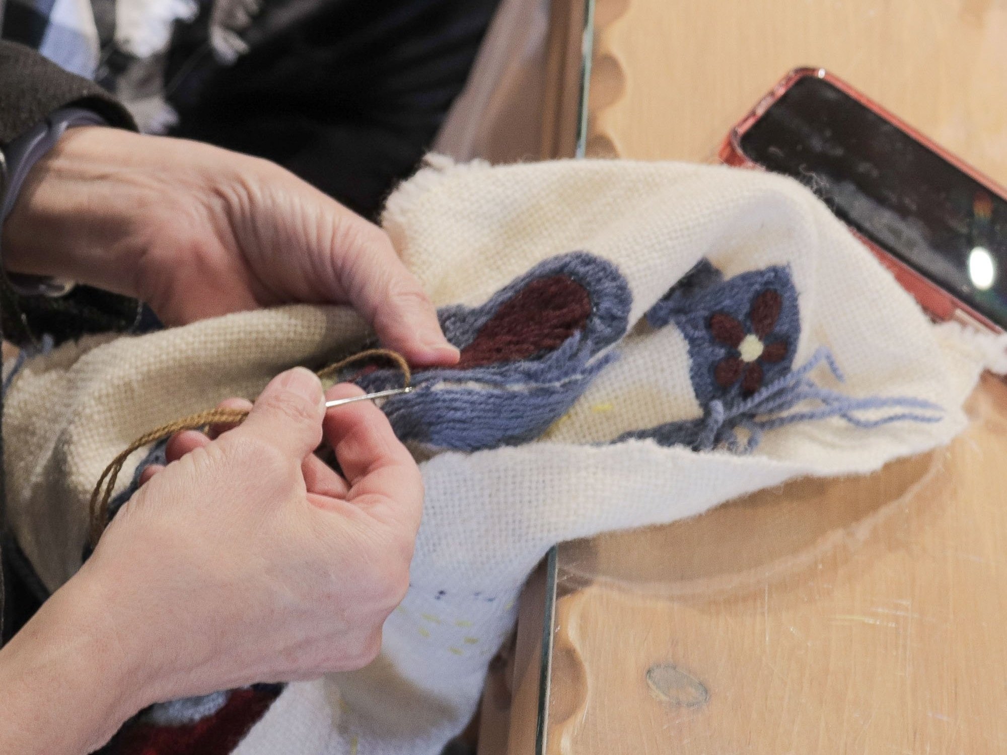 Stitching in Community • A Colcha Club participant carefully works on a traditional embroidery piece during a monthly gathering at the museum. These sessions bring together artists of all levels to share techniques, stories, and support.