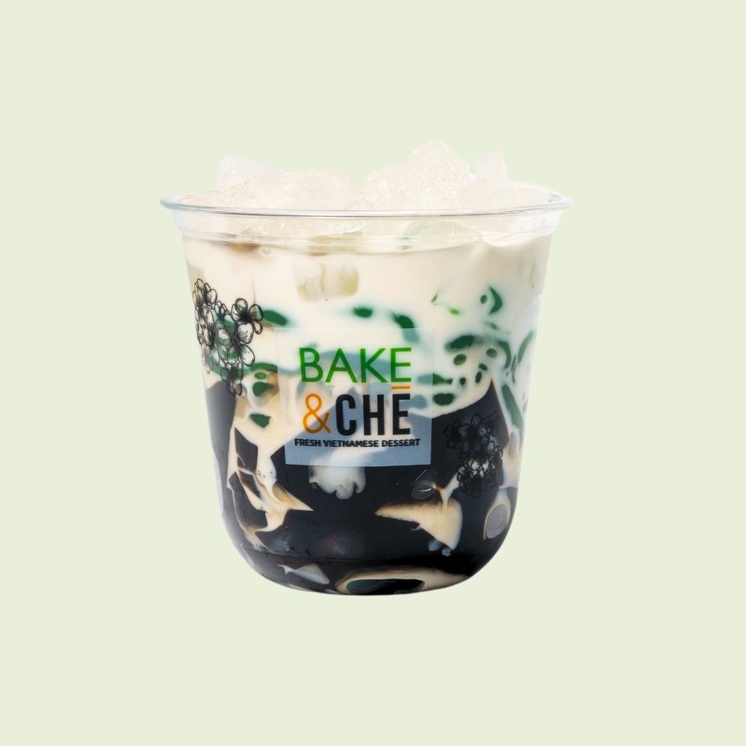 Vietnamese dessert with black jelly, coconut milk, and ice in a clear plastic cup, labeled 'Bake & Che'.