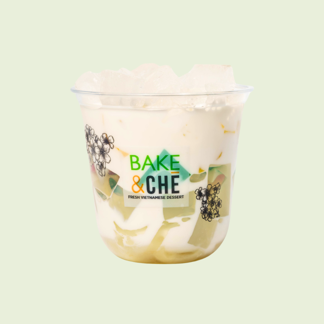A clear plastic cup containing a Vietnamese dessert with layered ingredients, including coconut milk, jelly, and fruit pieces, labeled 'Bake & Che, Fresh Vietnamese Dessert'.