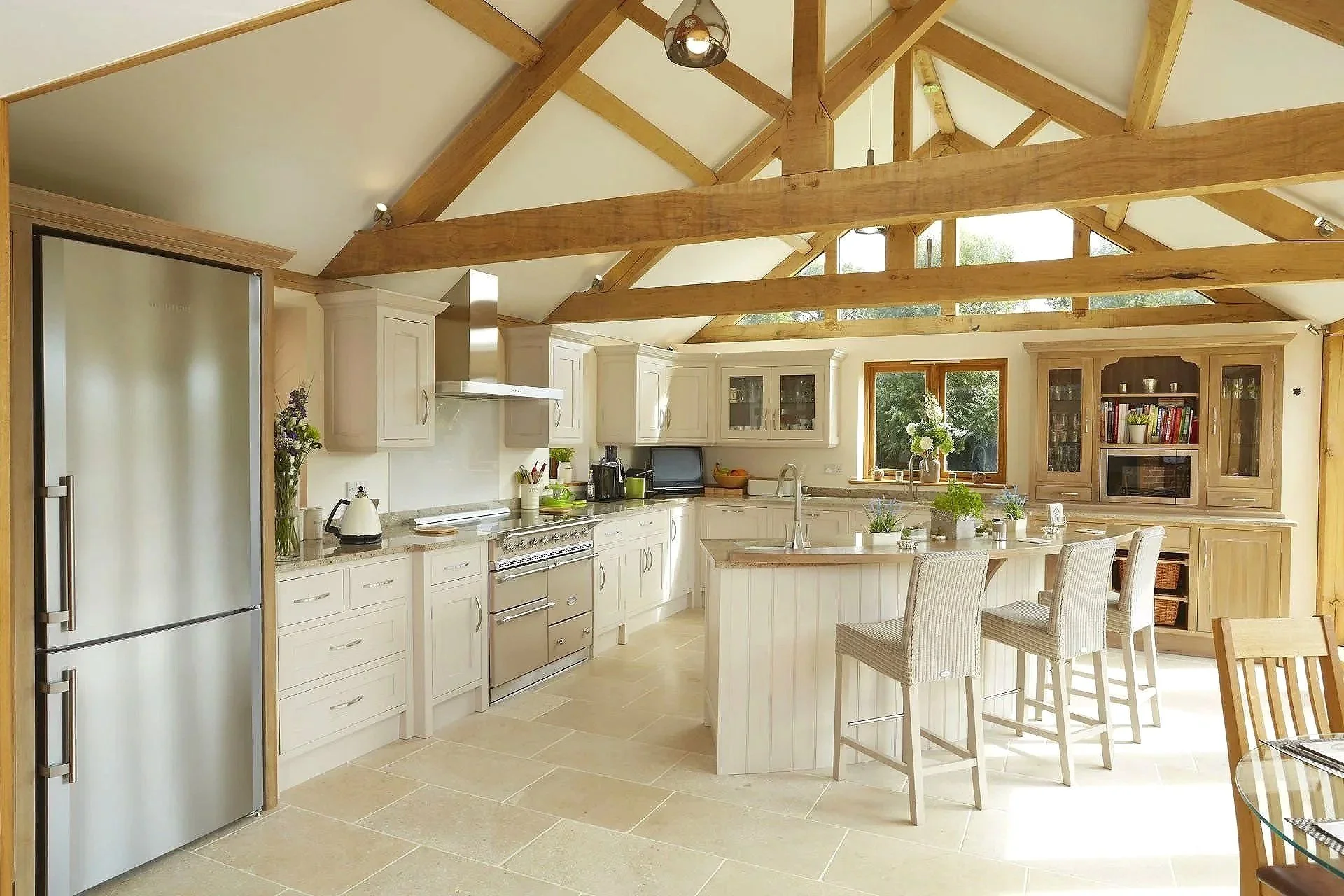 Open-plan kitchen with painted cabinetry, natural wood accents, and shaped central island