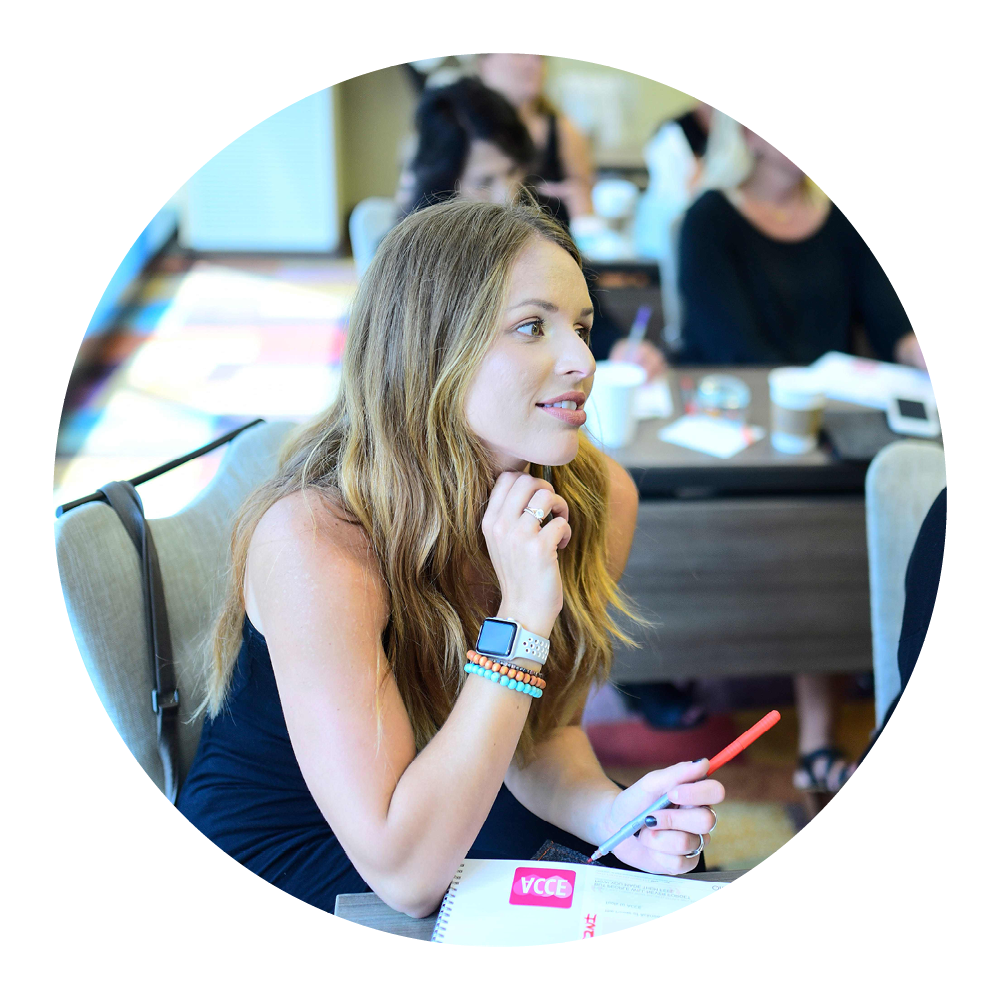 Person using a smartwatch and holding a pen, attending a meeting with notebooks on the table.