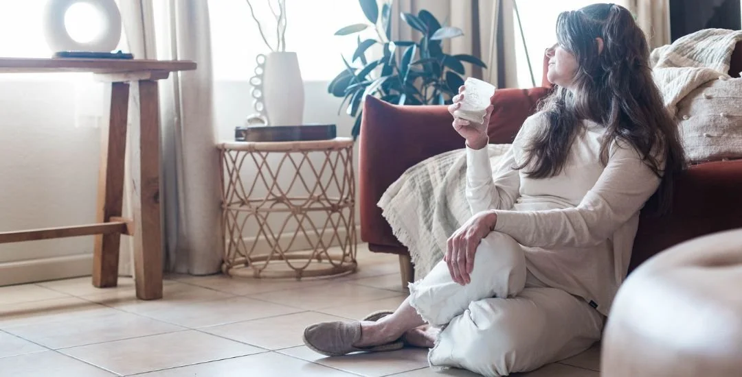 Woman drinking milk, sitting on the floor