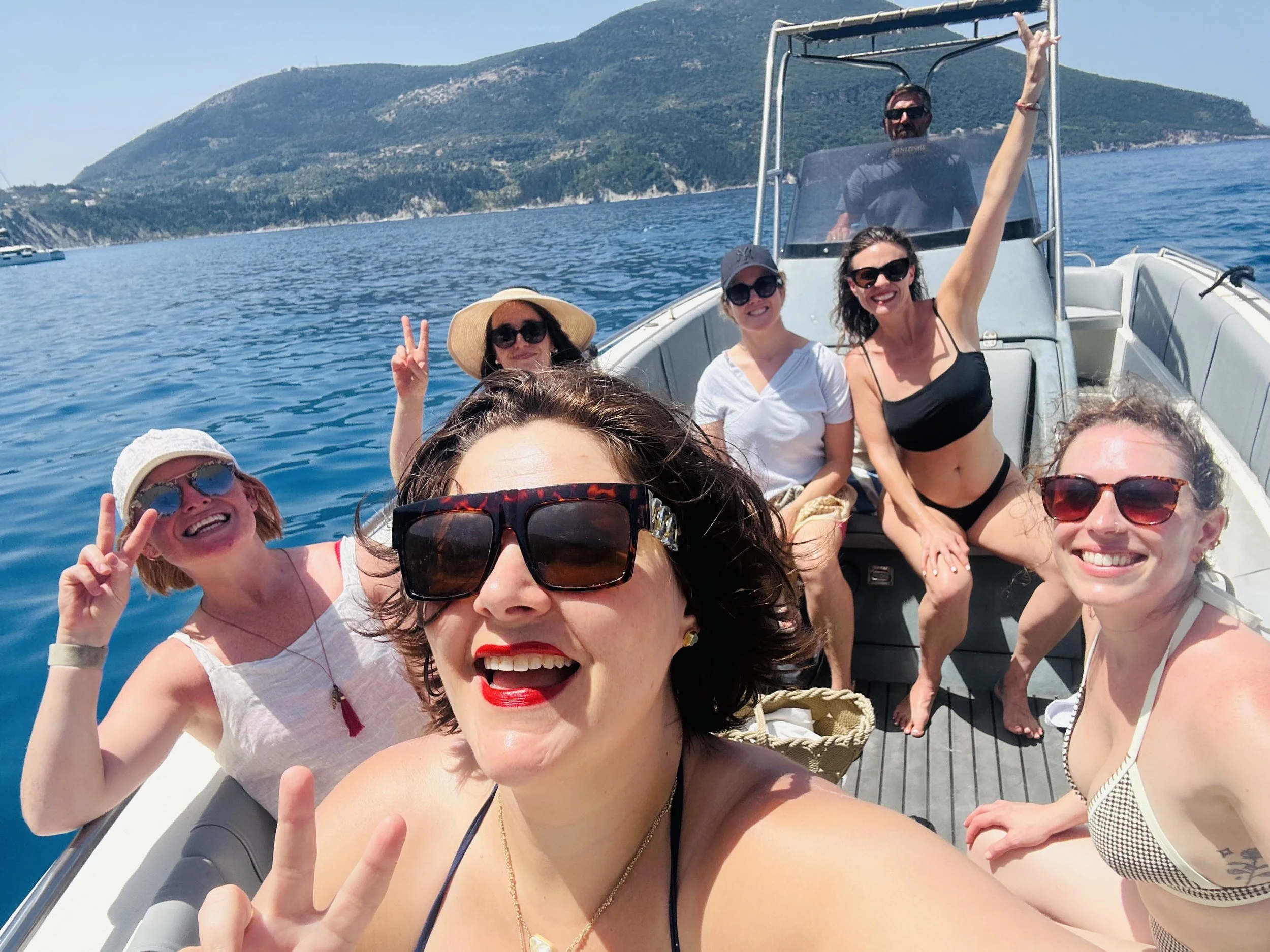 Women enjoying a summer boat trip during a retreat in Italy