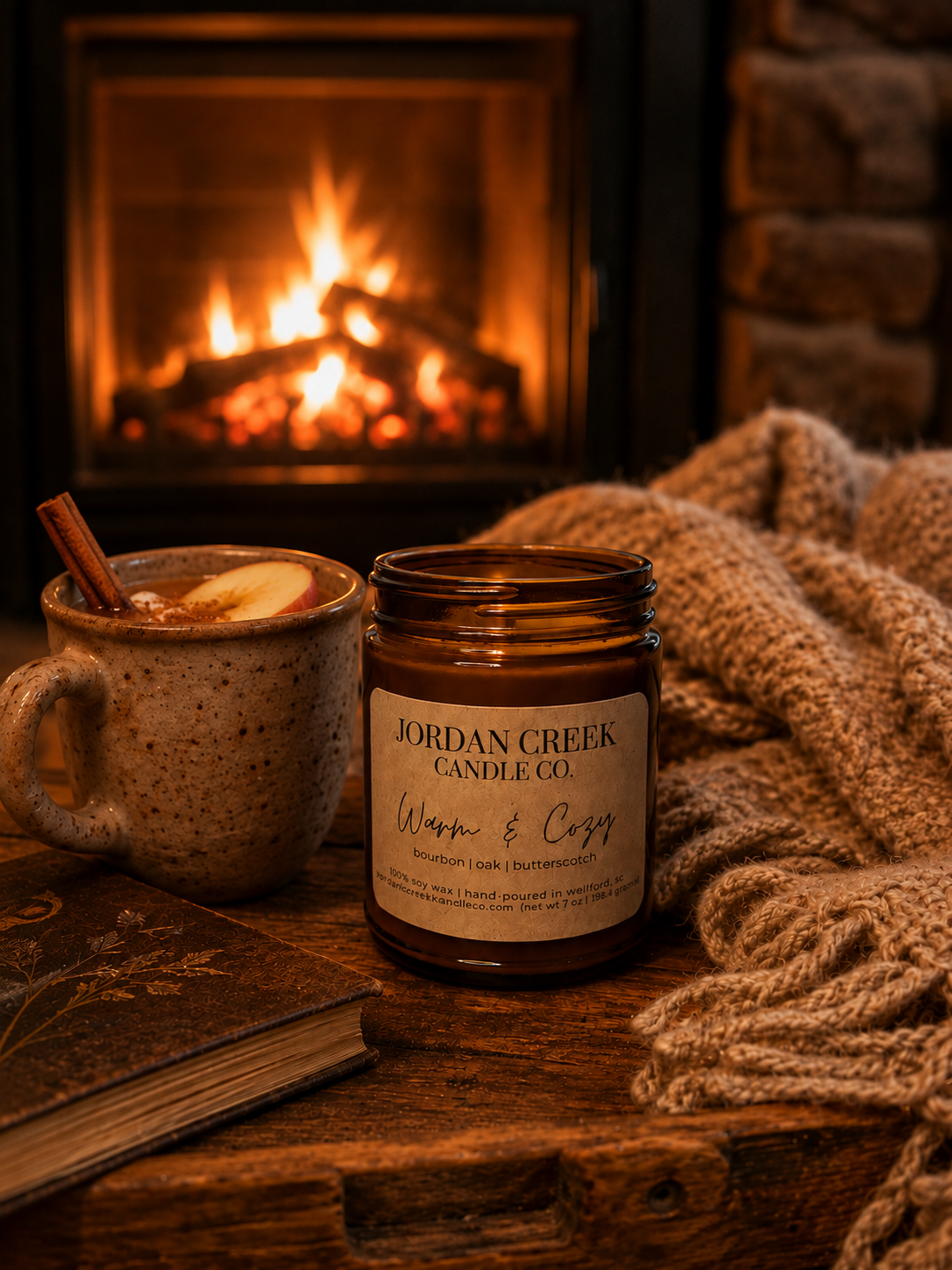 warm & cozy candle sitting in front of a roaring fireplace
