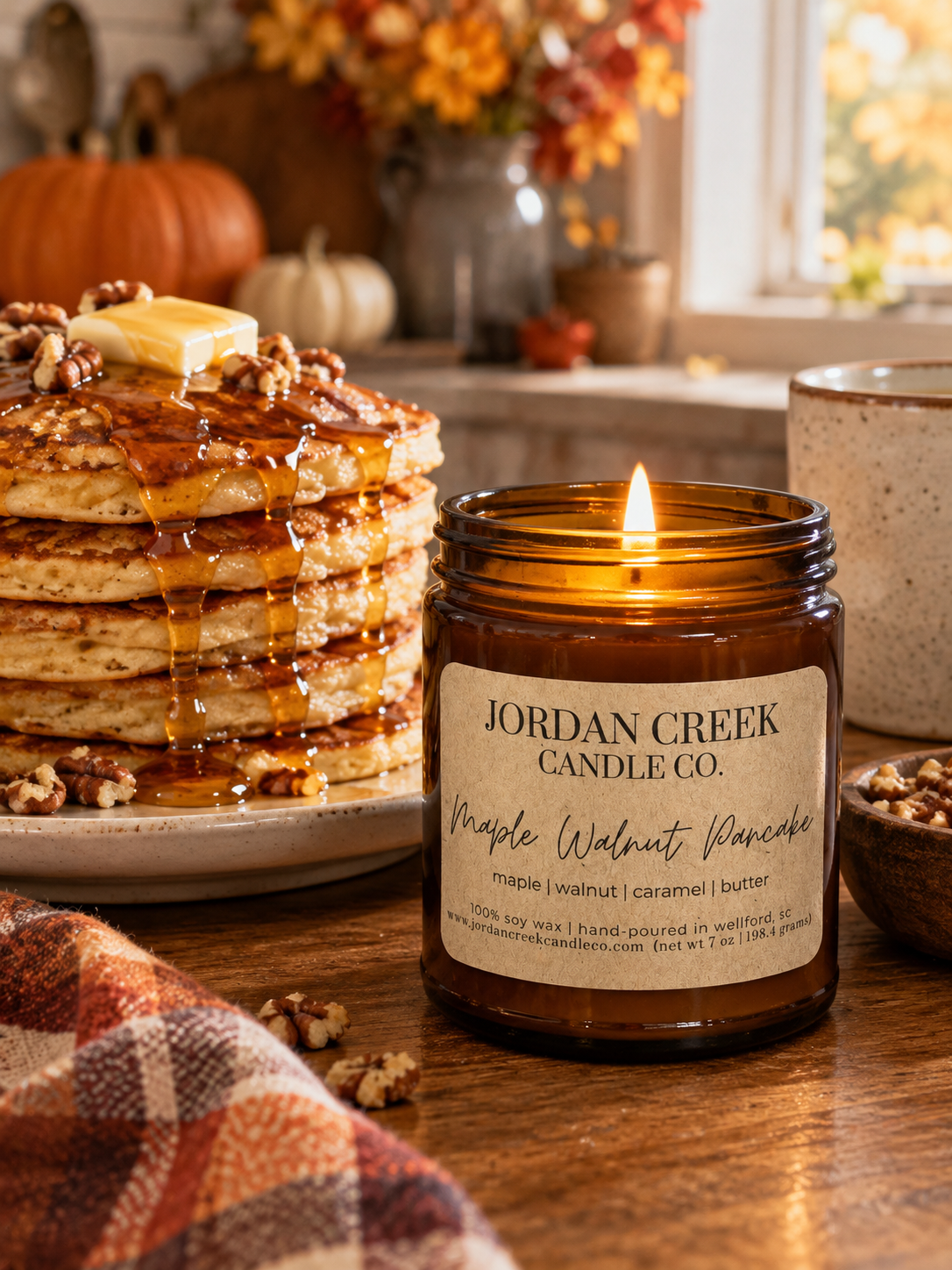 maple walnut pancake candle sitting next to a tall stack of pancakes