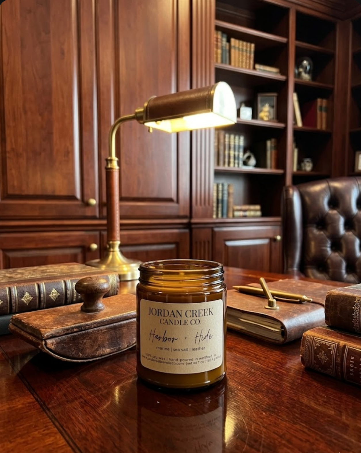 Harbor and Hide candle sitting on a mahogany desk