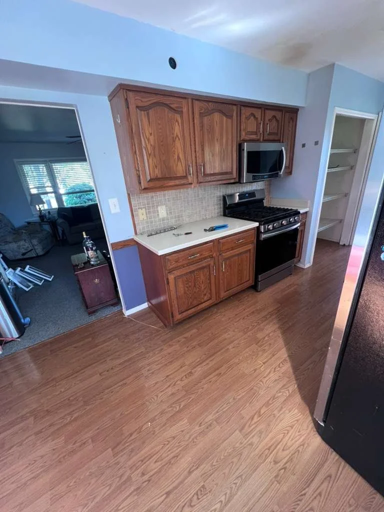 Before renovation: original wood kitchen cabinets, range and older flooring.