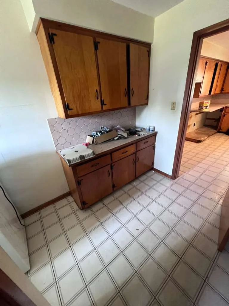 Pantry area before renovation with older wood cabinets.