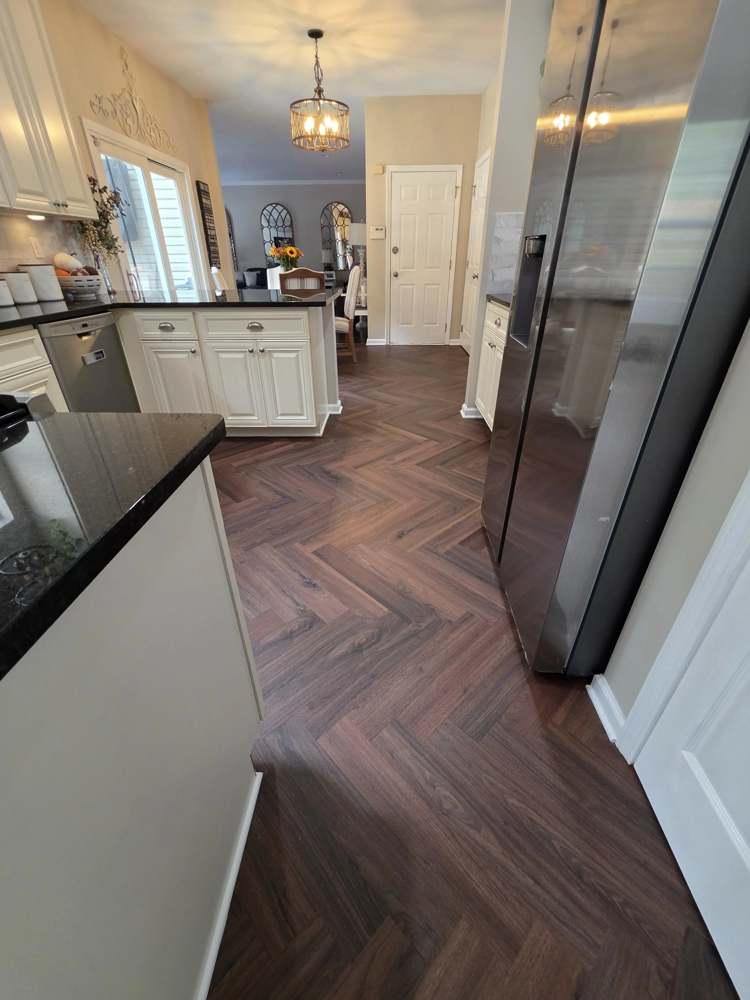 Herringbone-pattern vinyl floor through the kitchen walkway.