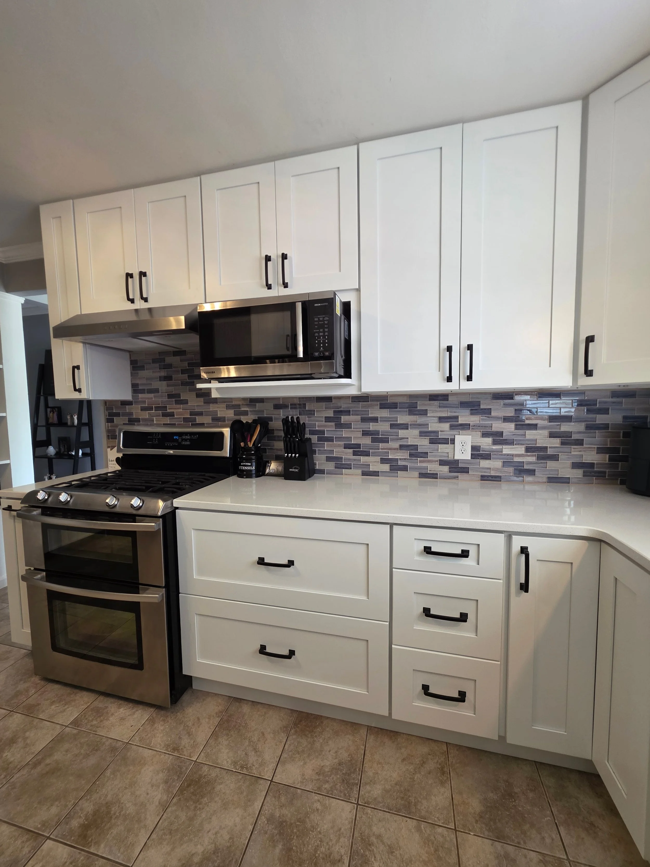 White cabinets and stainless microwave above the range.