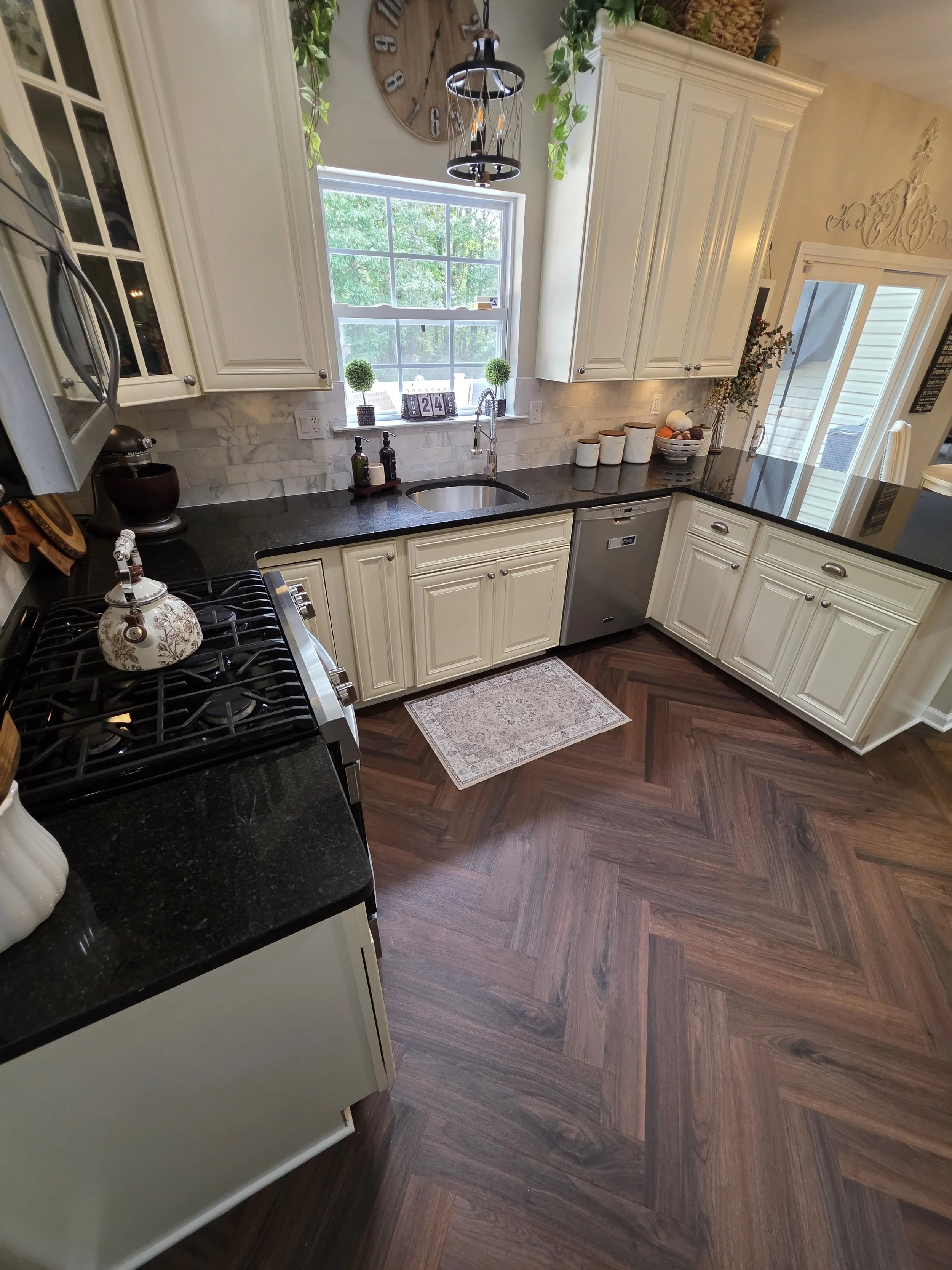 New vinyl flooring and backsplash beside kitchen sink.