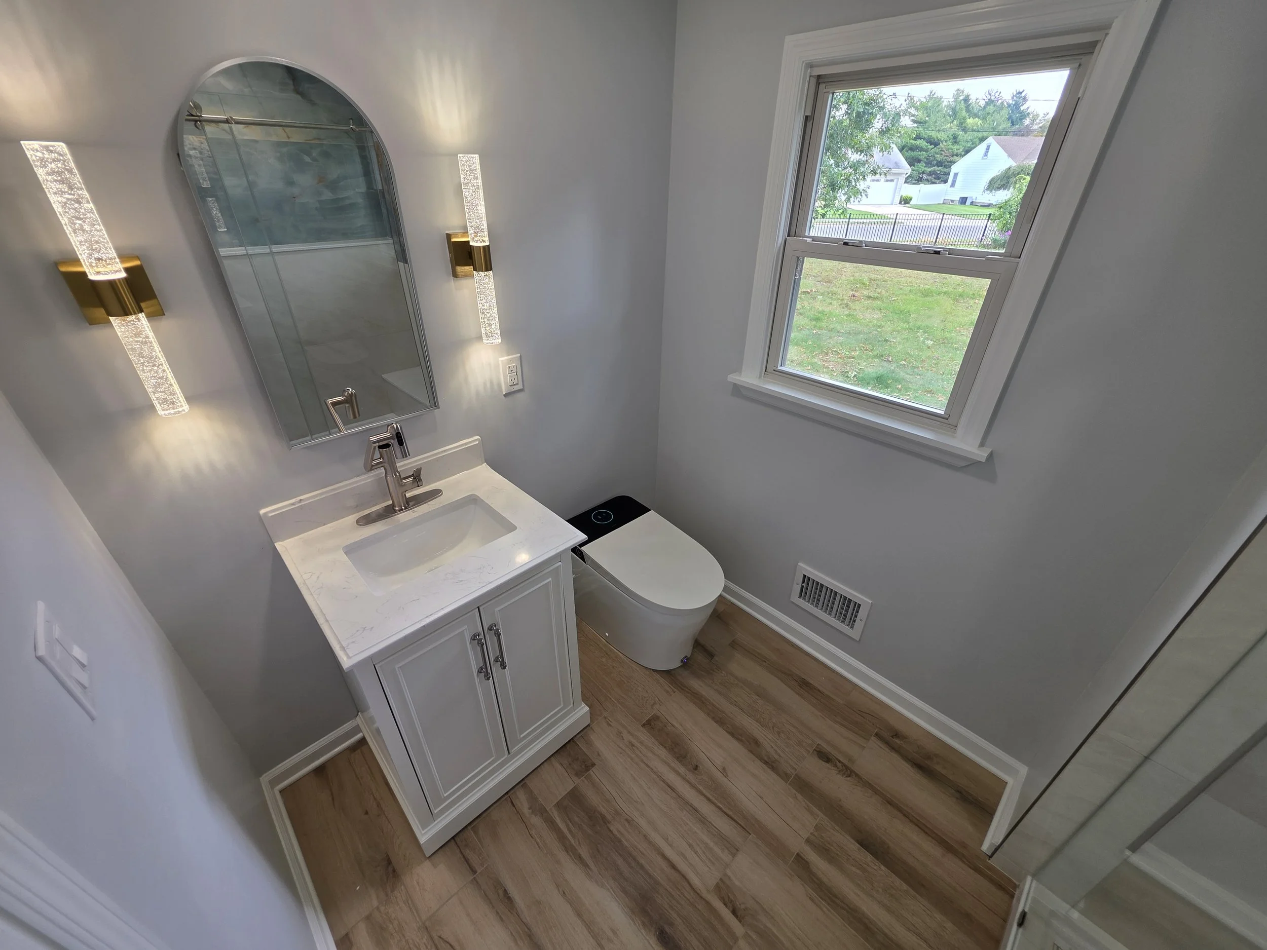First-floor bathroom vanity, arched mirror and window.