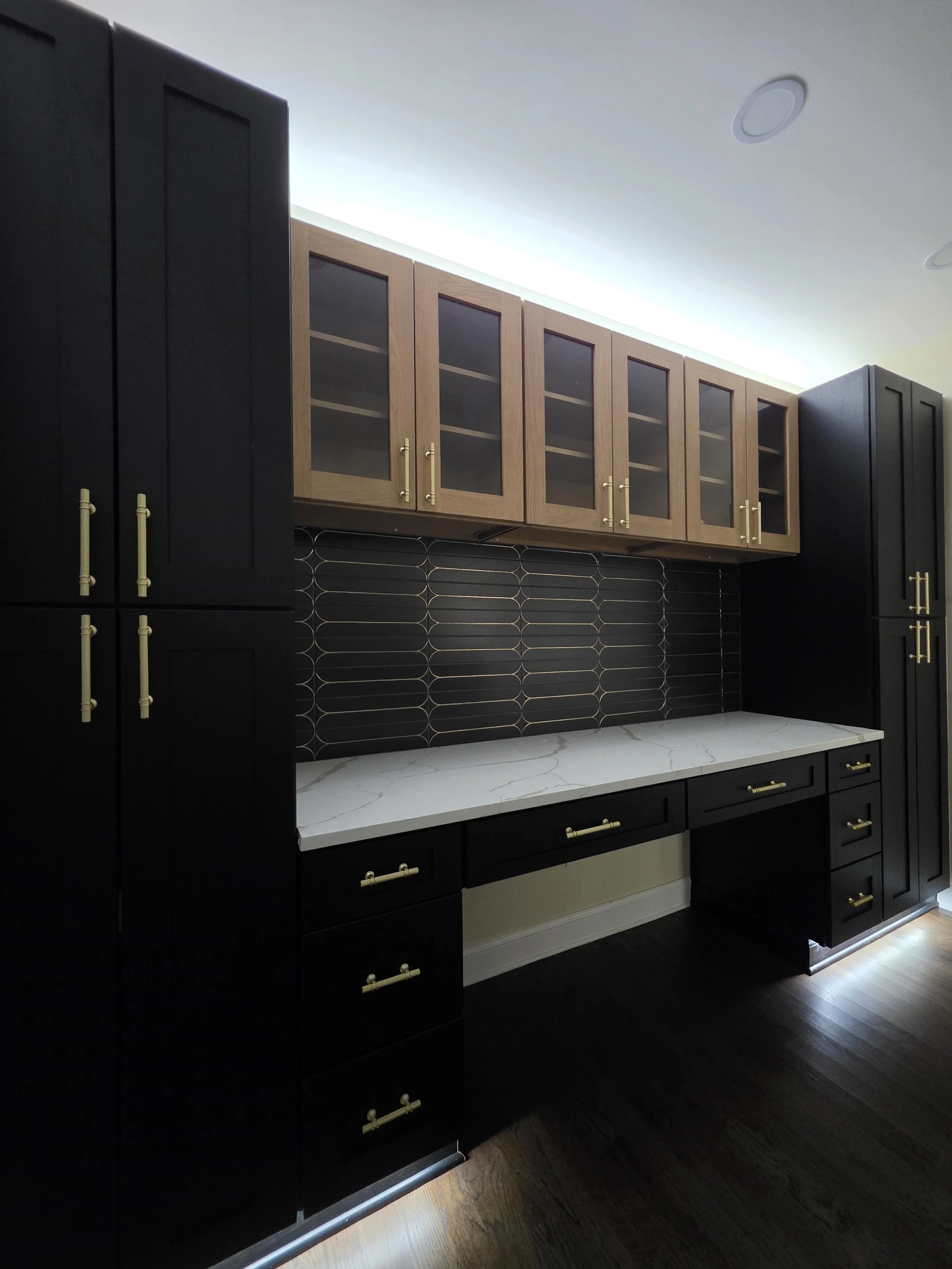 Built-in office drawers and cabinets with gold-toned hardware.