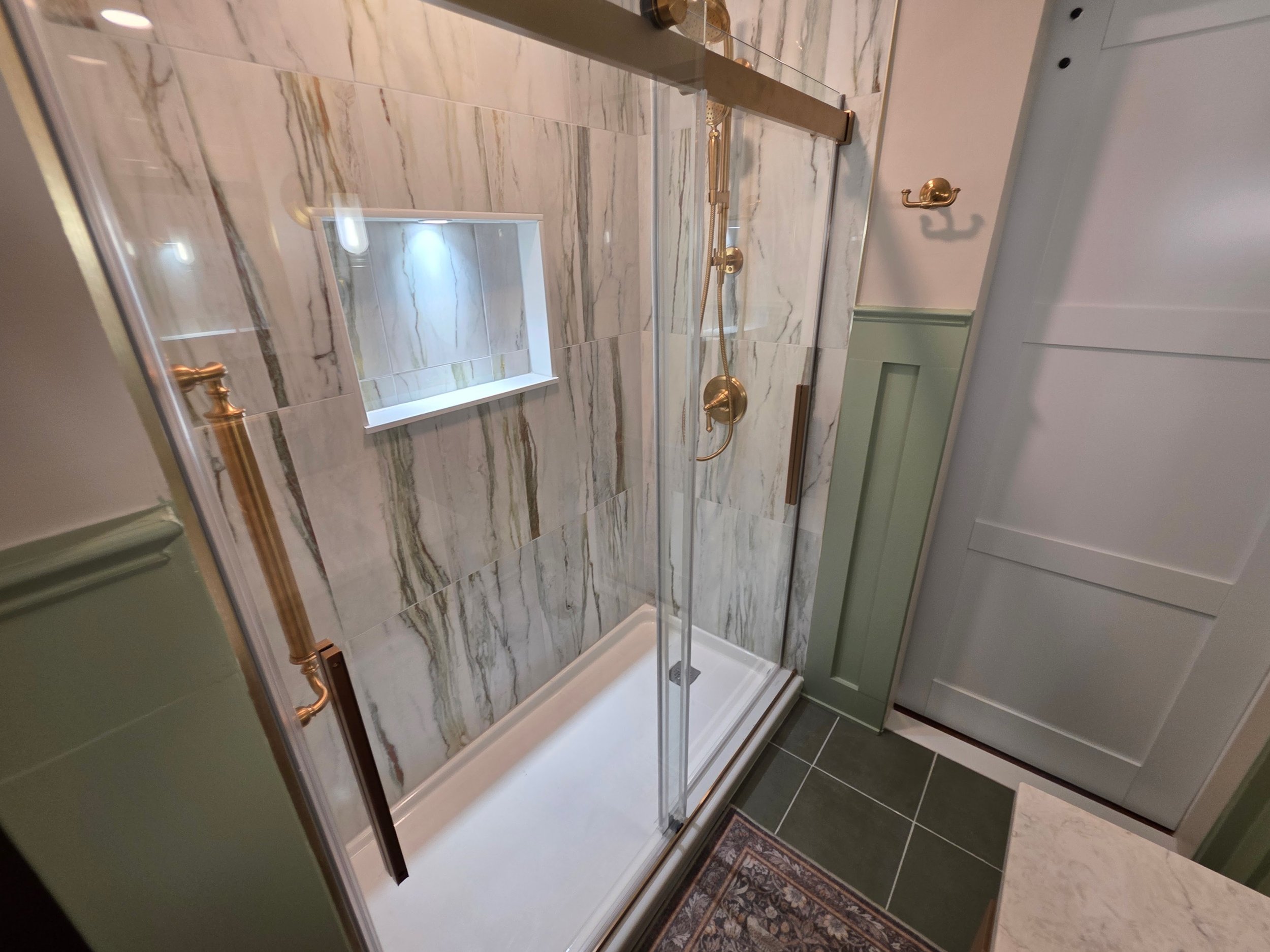 Shower enclosure and patterned floor viewed from vanity.