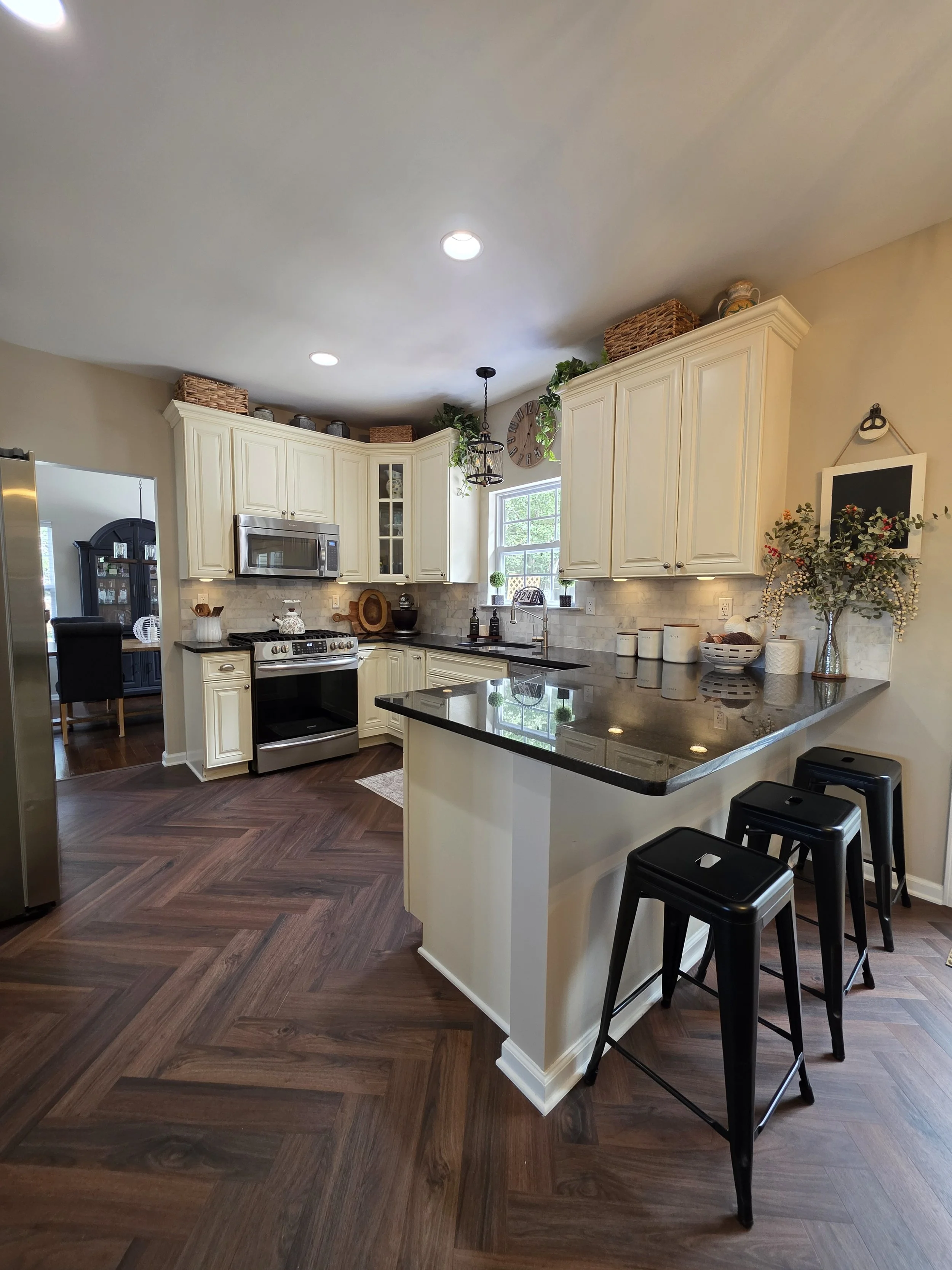 Updated backsplash and vinyl flooring around existing kitchen cabinets.