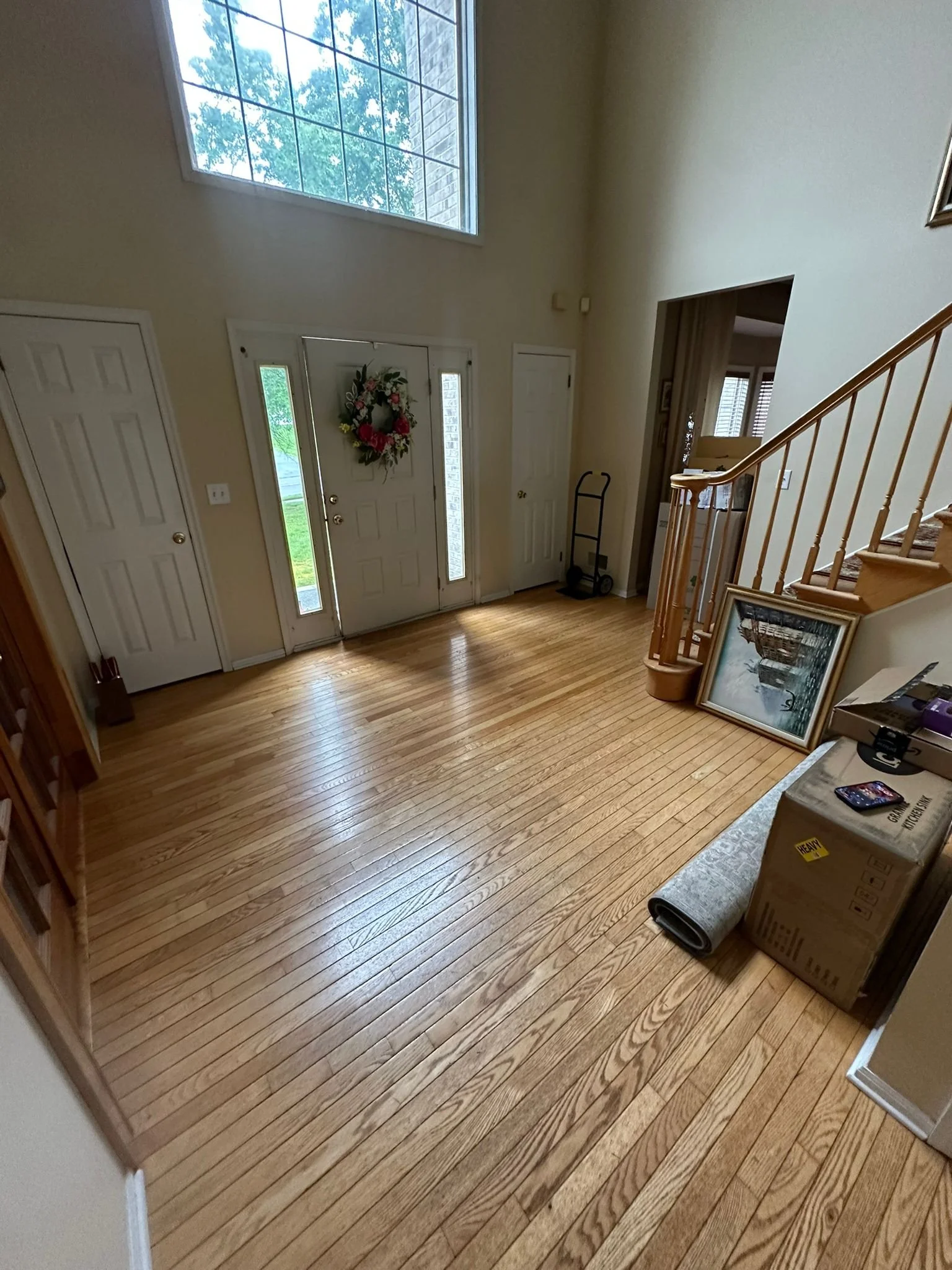 Before renovation: the original entryway and wood stair railing.