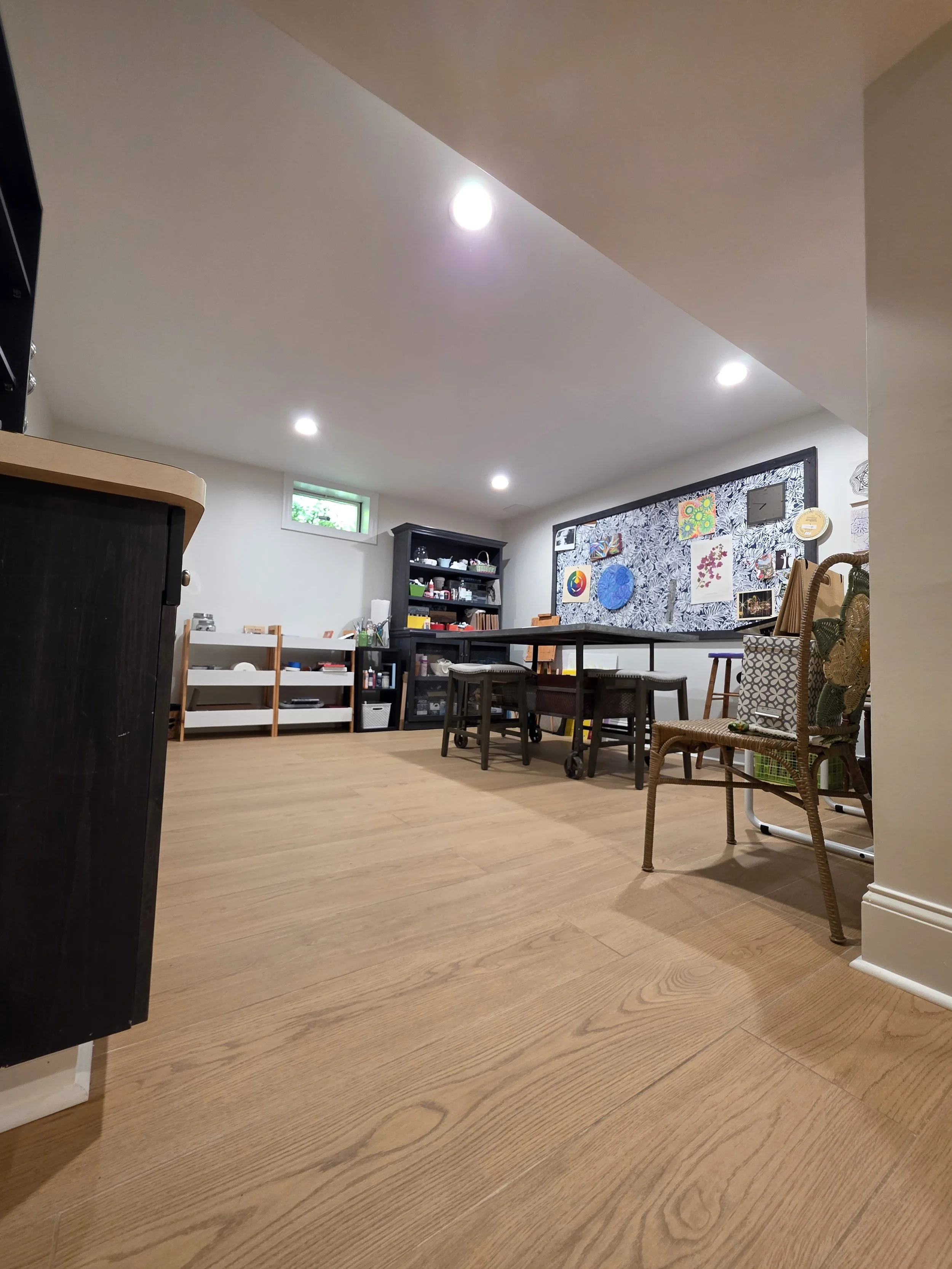 Basement recreation area with continuous wood-look tile.