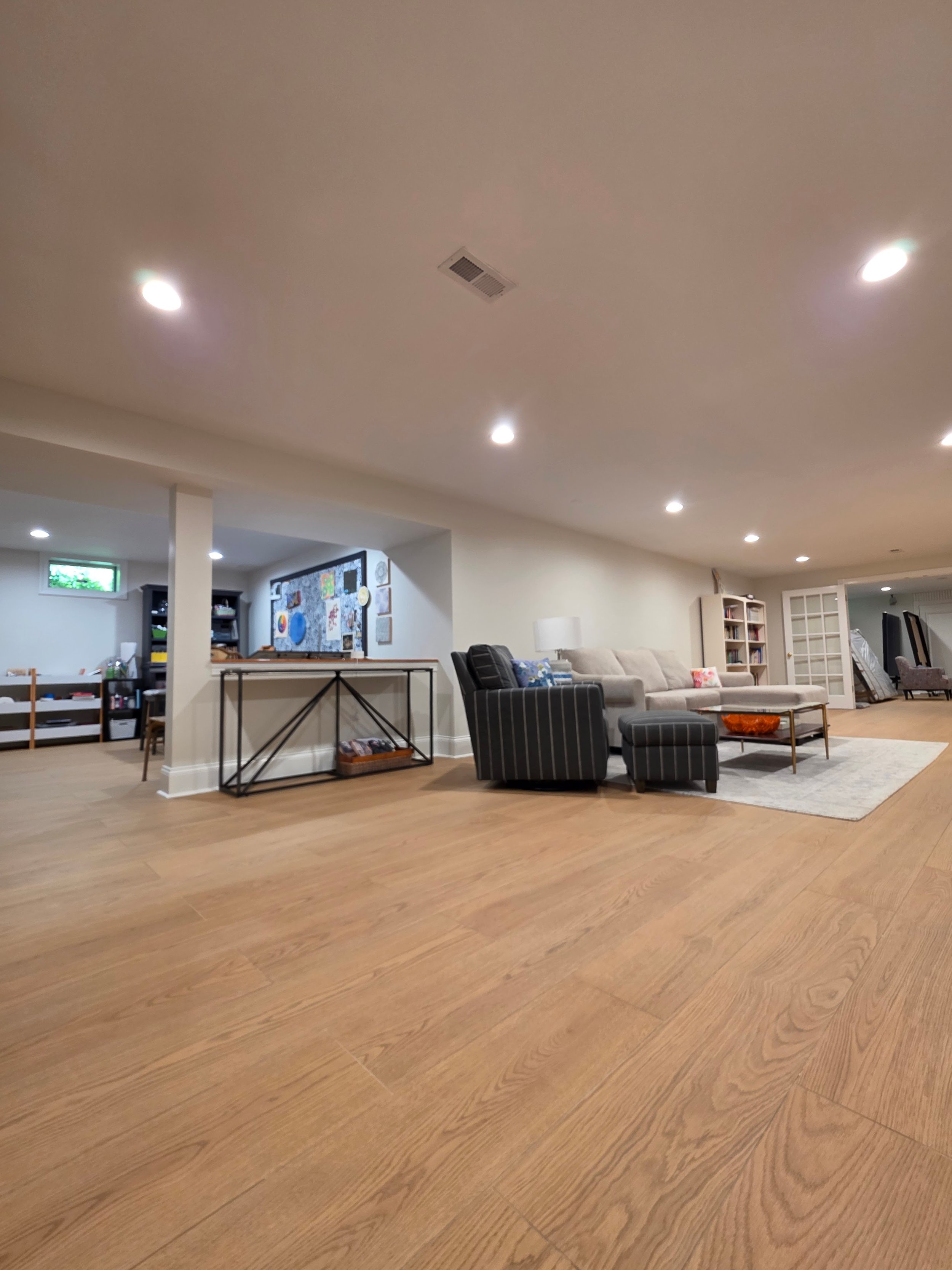 Wood-look floor beside recreation and lounge areas.