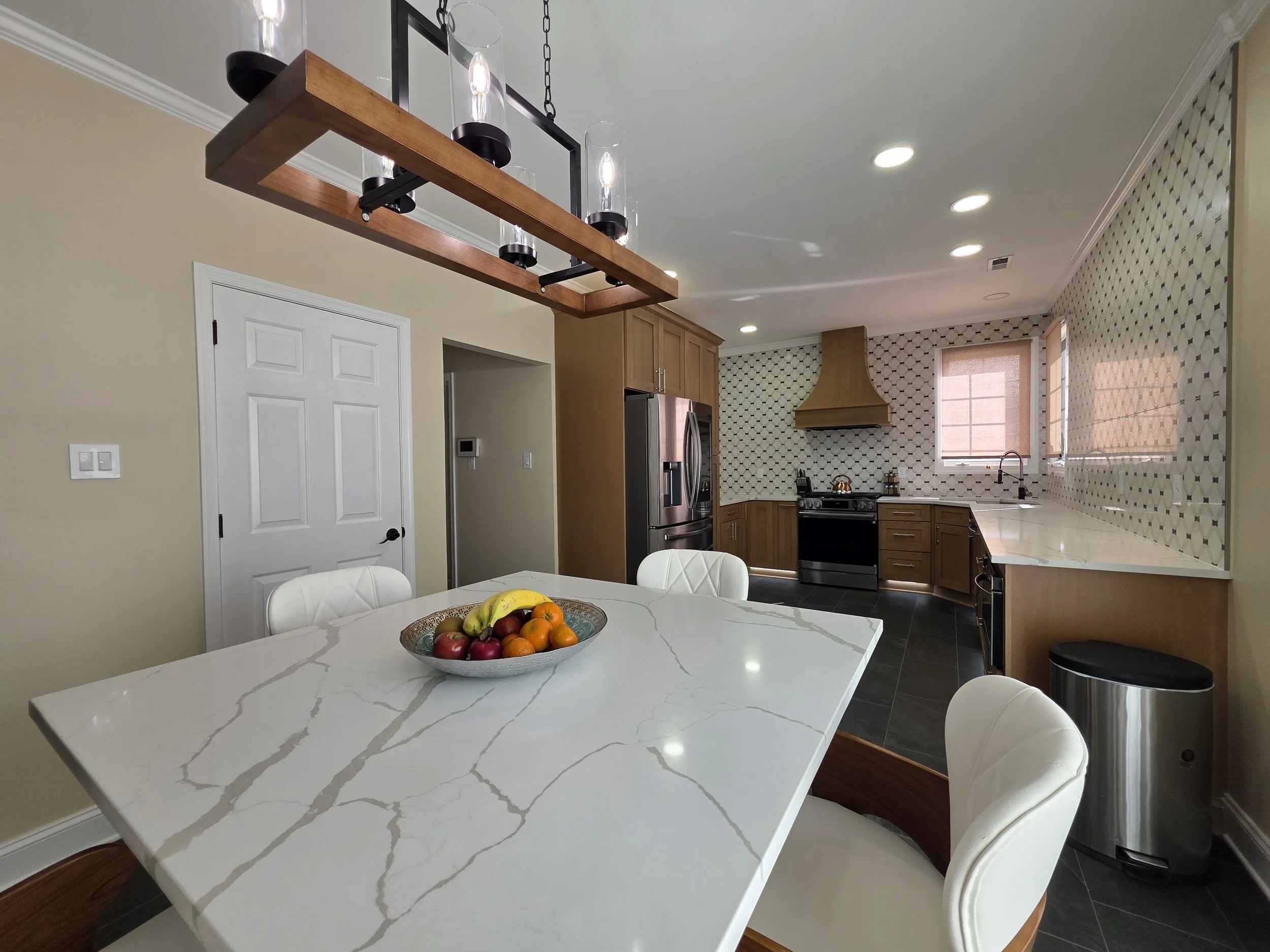 Light island countertop and dining stools with linear pendant.