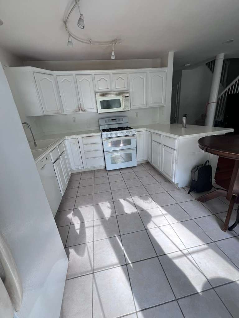 Before renovation: the original kitchen range, cabinetry and square tile flooring.