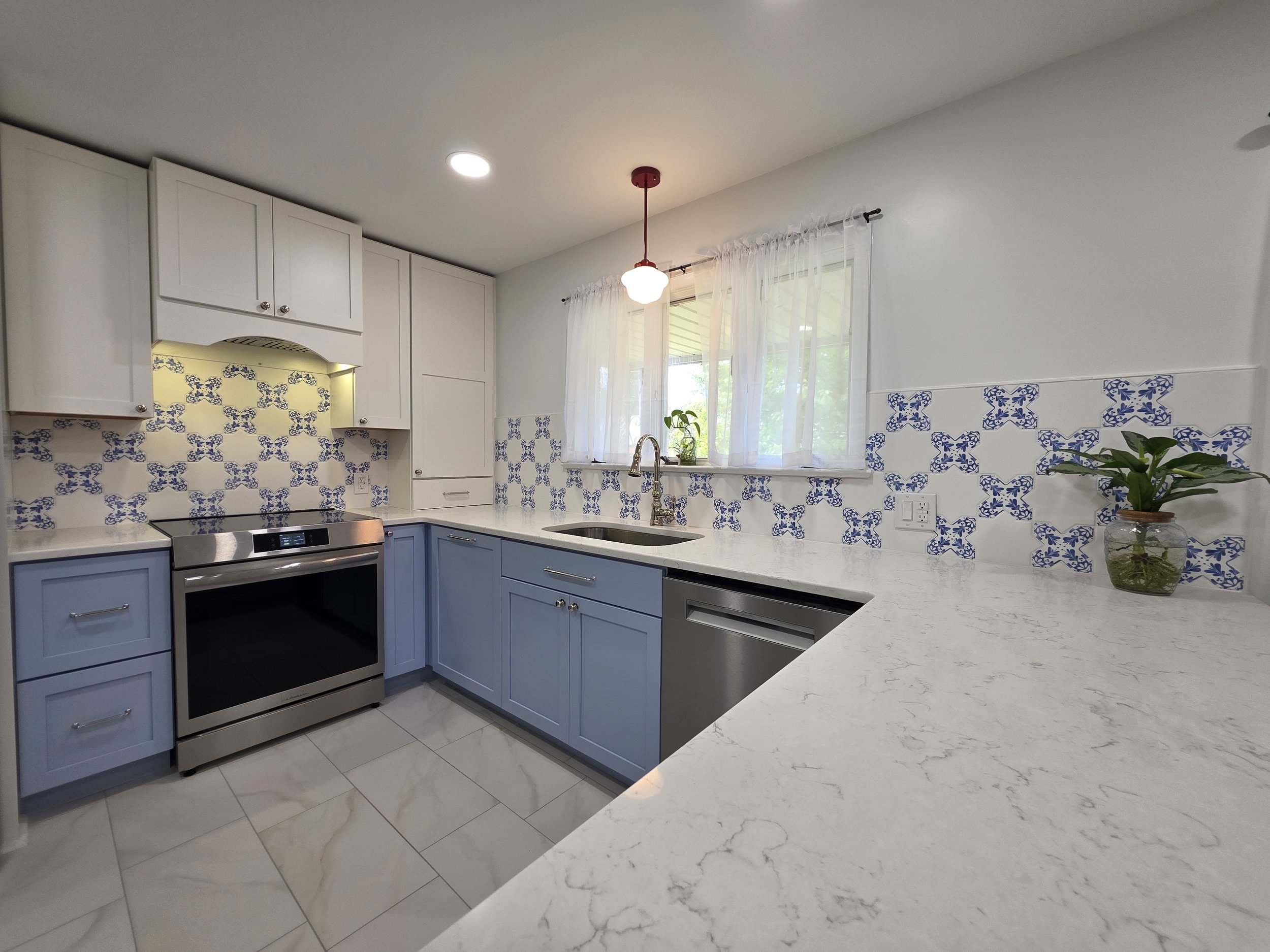 Range surrounded by blue and white cabinetry.
