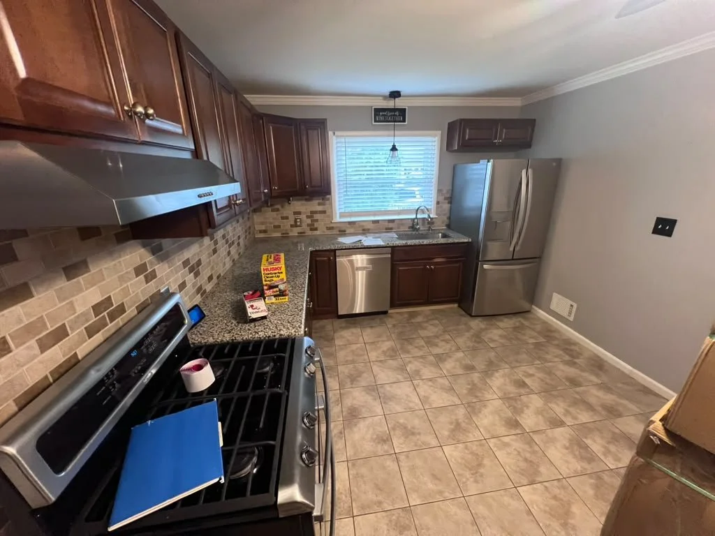 Kitchen before renovation with wood cabinets.