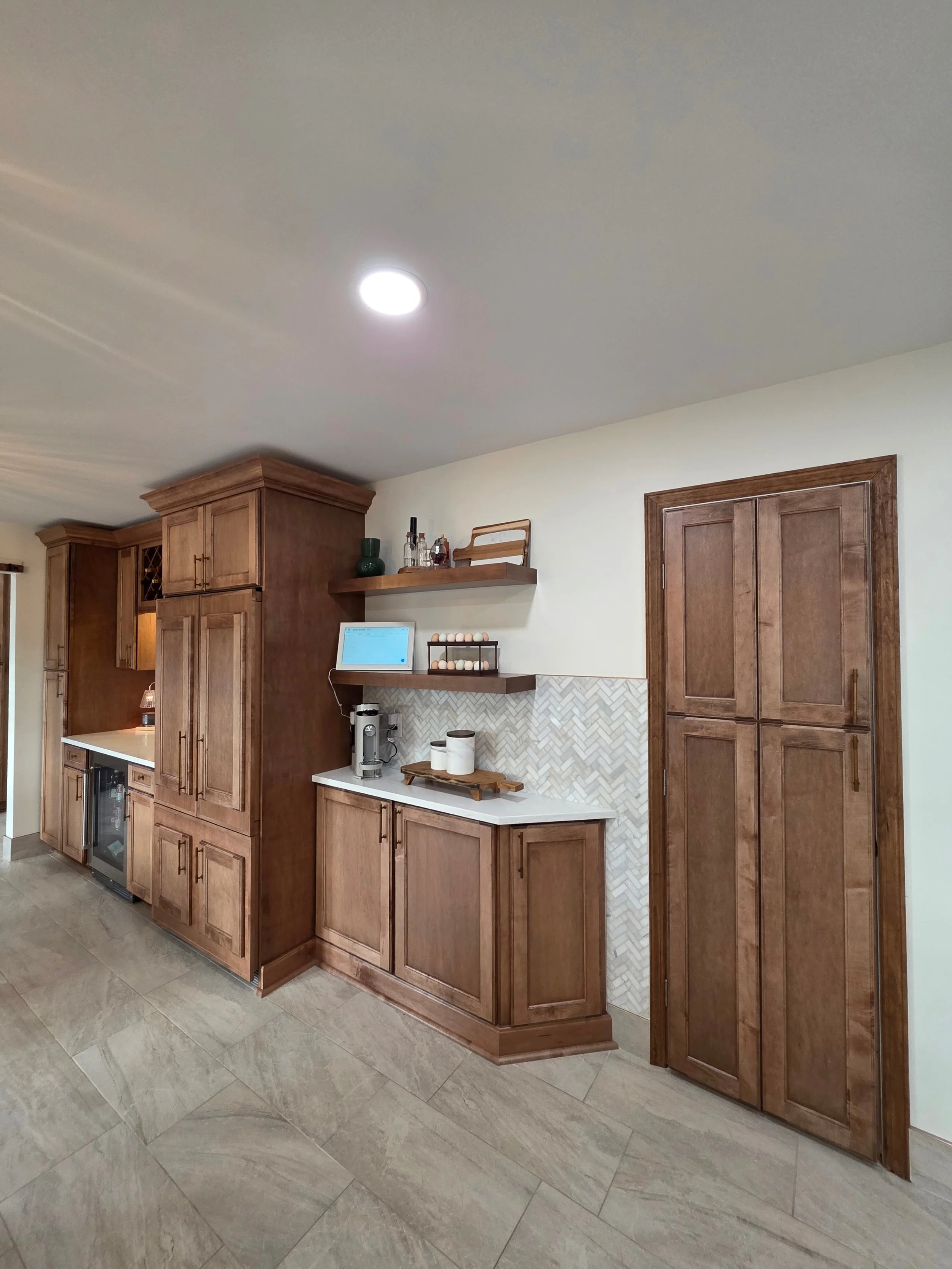 Wide view of the tall wood cabinetry and coffee station on the adjoining wall.