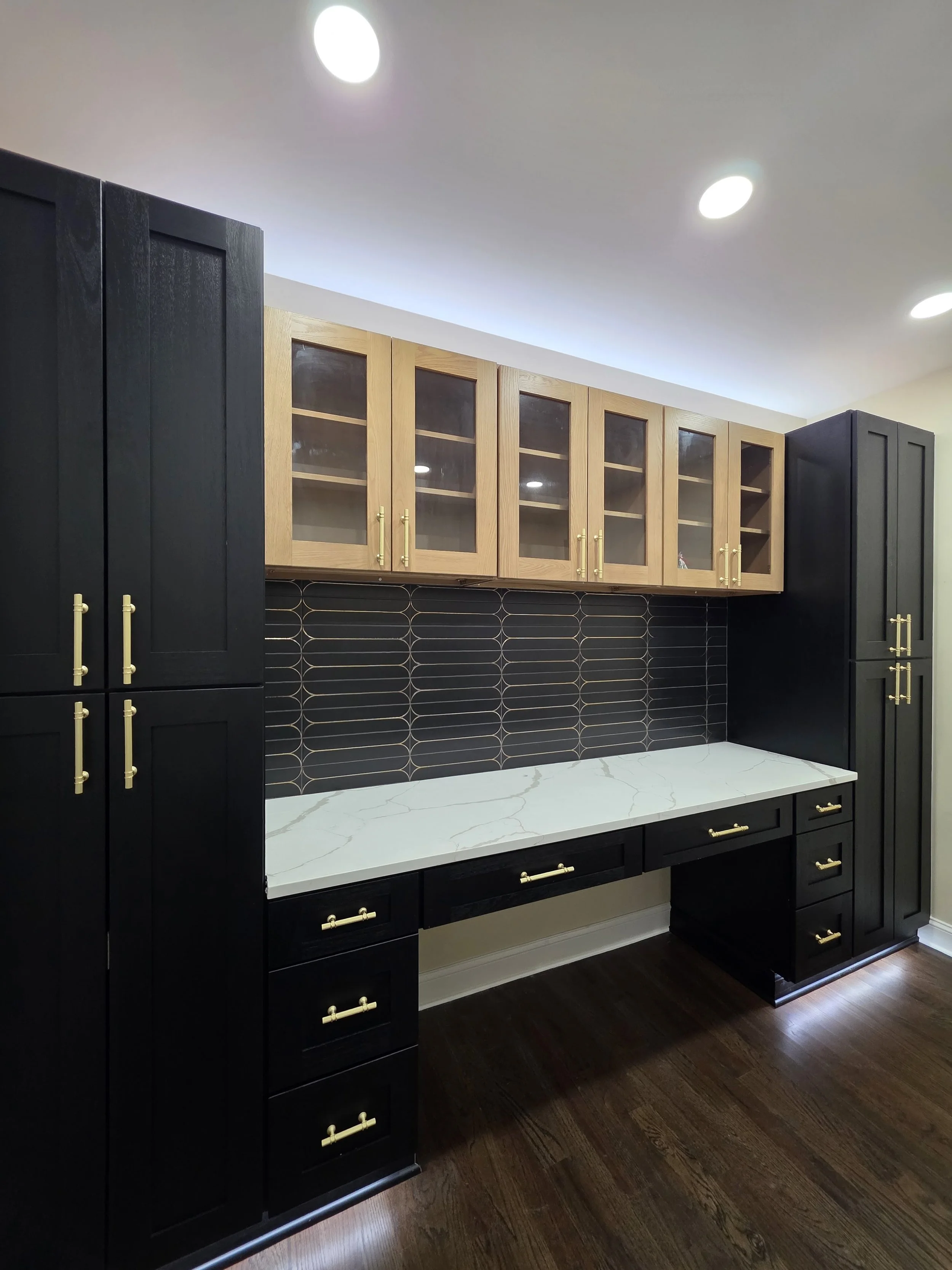 Augusta’s office with dark built-in cabinetry and wood-framed glass upper doors.