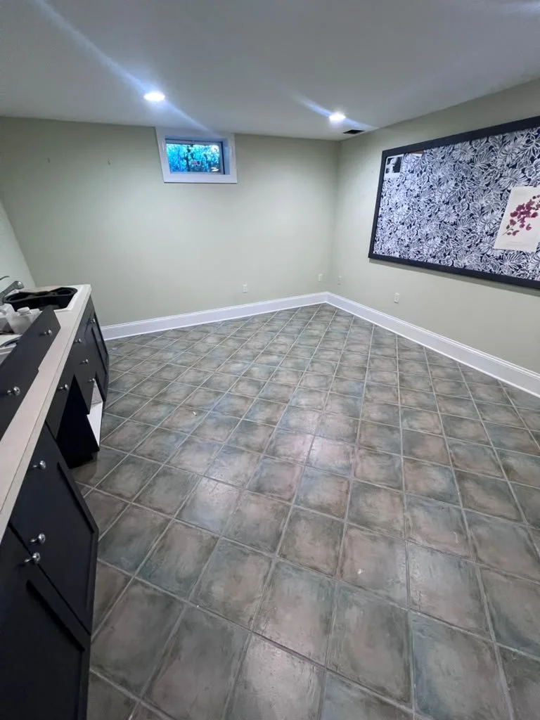 Basement before renovation with older patterned tile.
