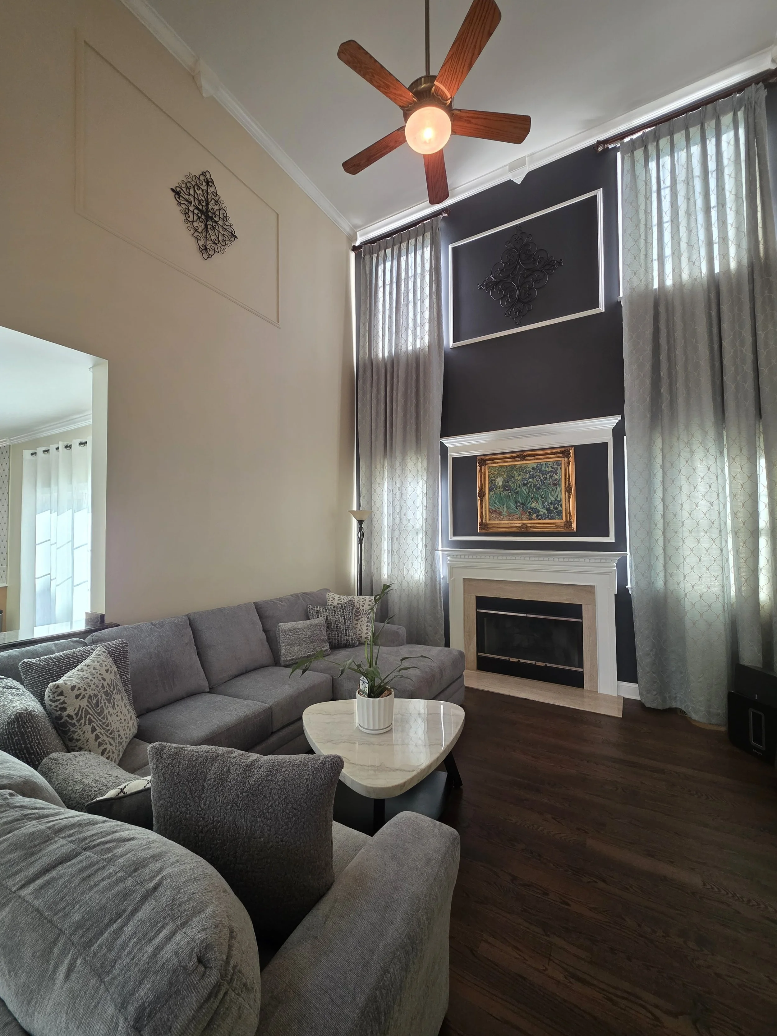 Augusta’s freshly painted living room with tall walls and fireplace.
