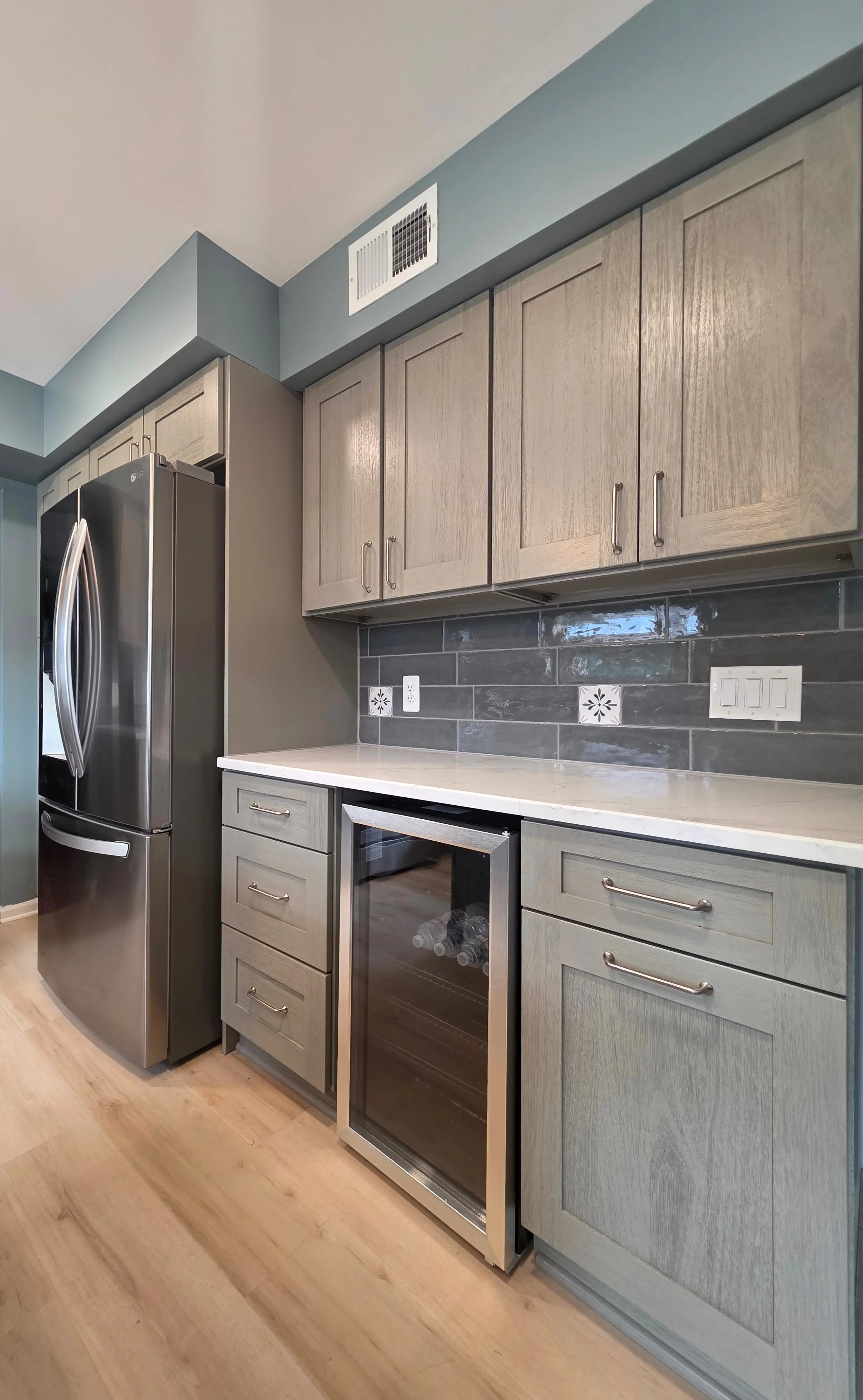Cabinetry and beverage refrigerator beside the island.