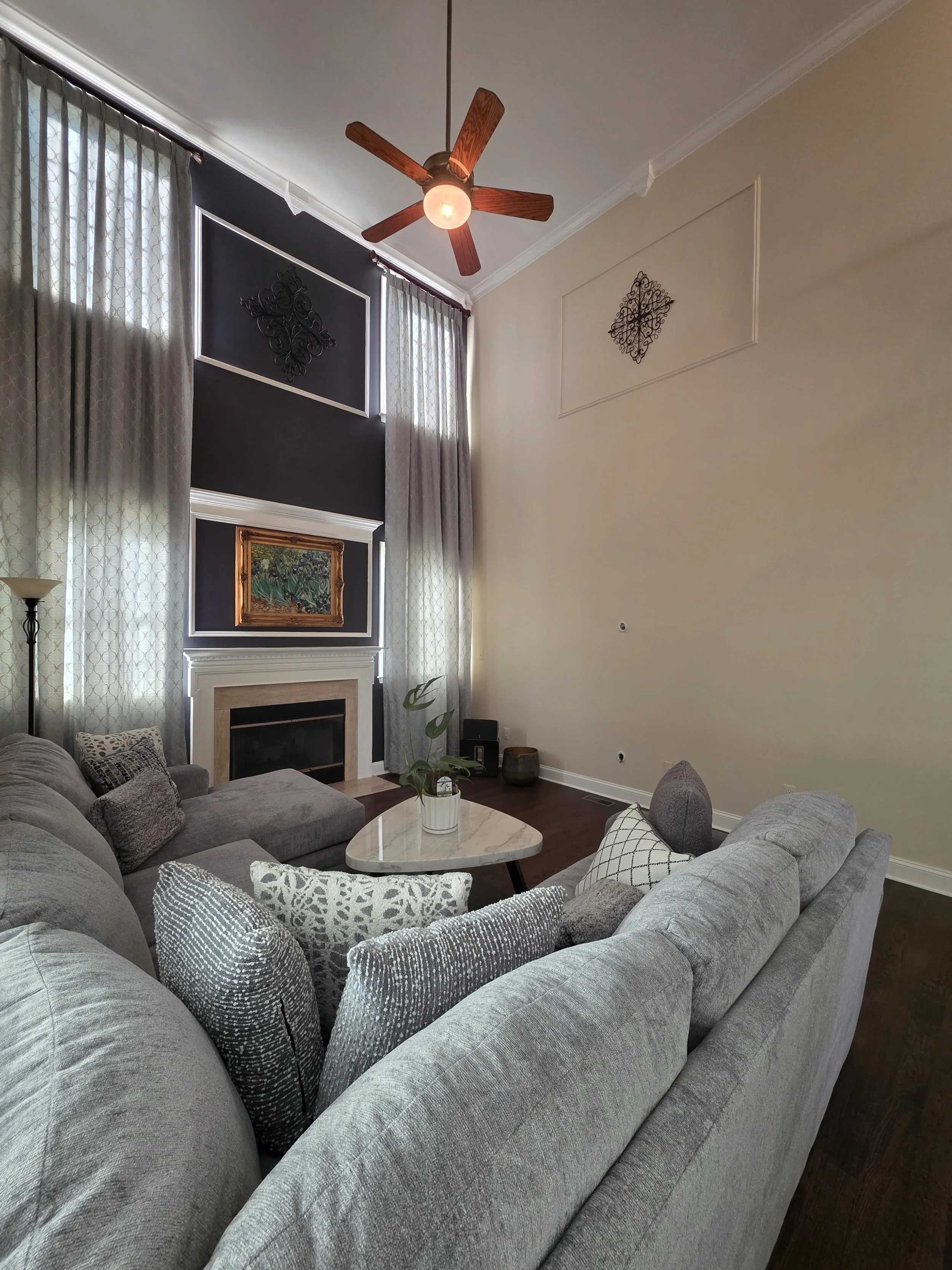 Living room paint and trim around tall windows and fireplace.