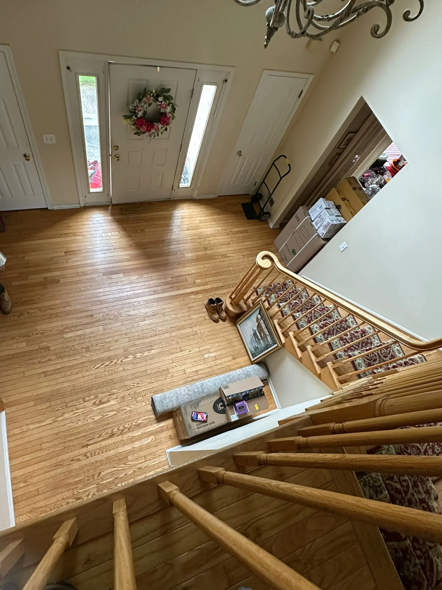 Before renovation: view from the original staircase down to the entry door and wood floor.