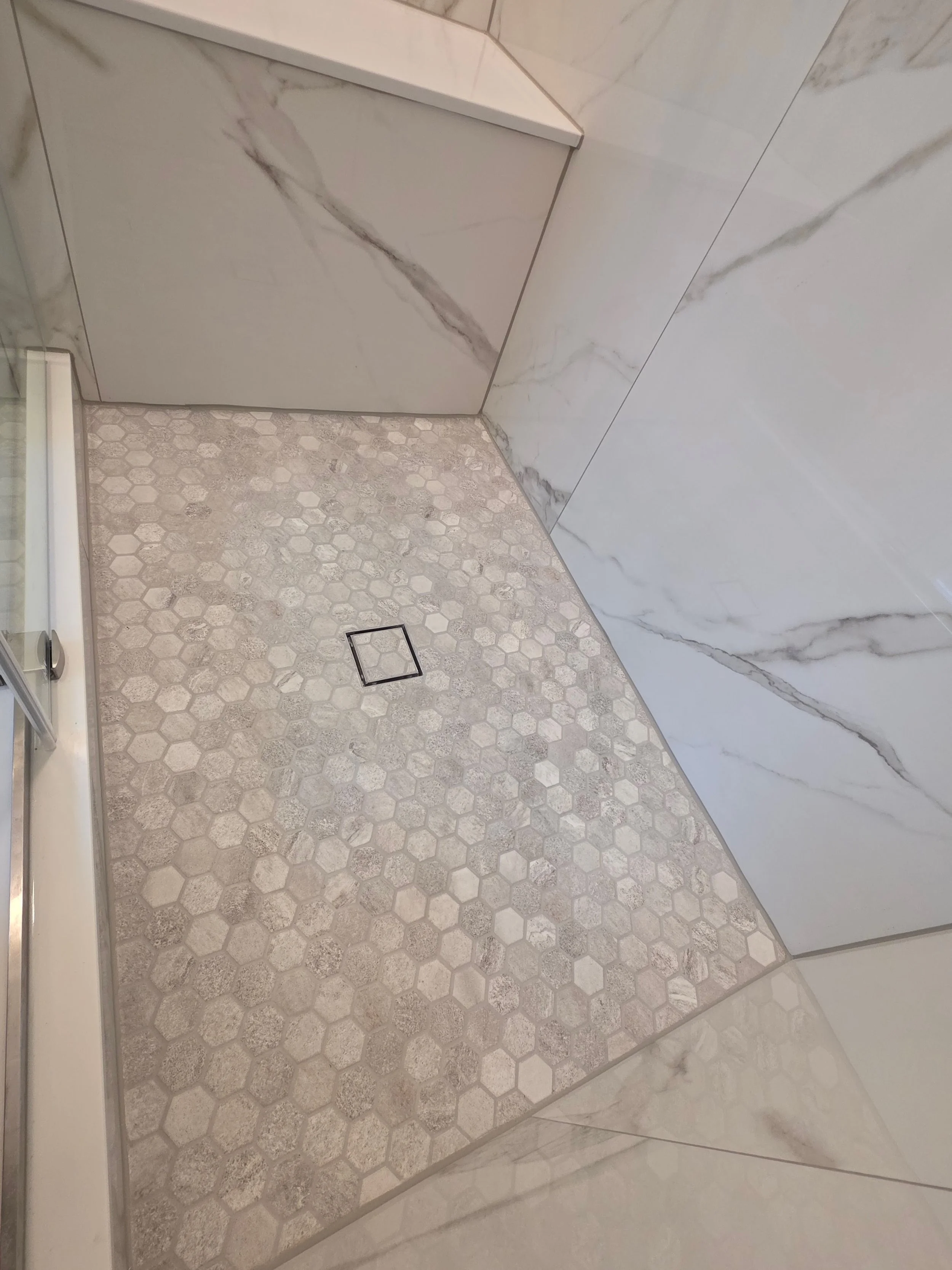 Shower floor mosaic and wall tile details.
