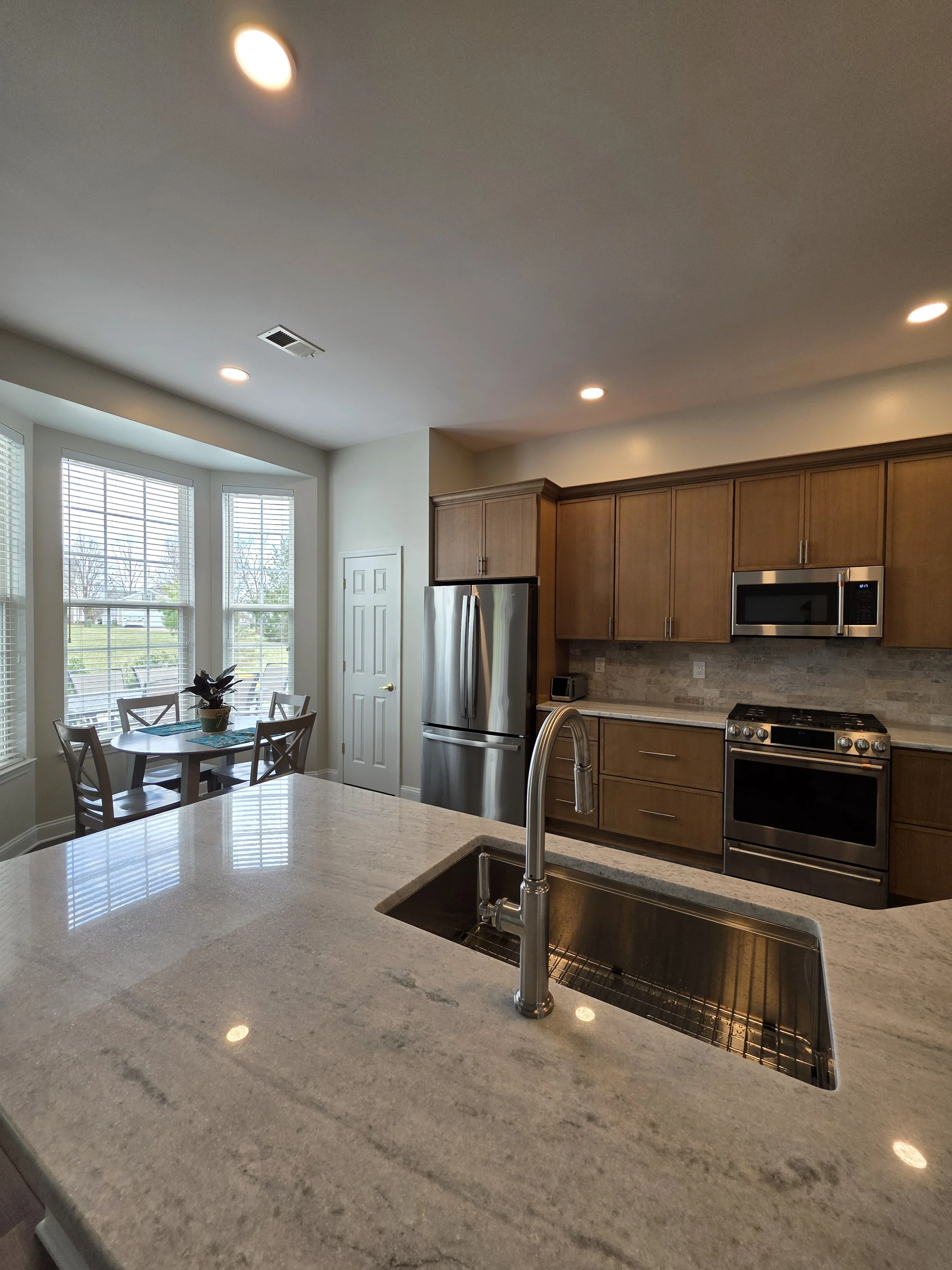 Peninsula sink looking across the kitchen toward the range and refrigerator.