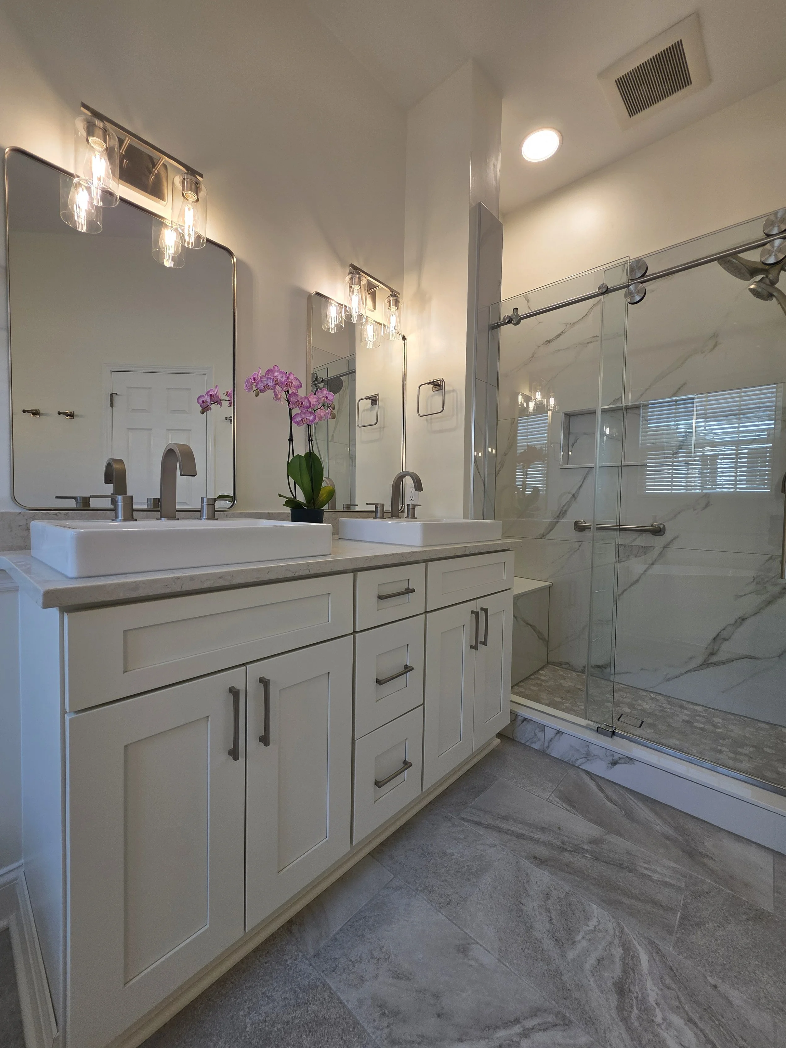 Sink vanity beside glass shower enclosure.