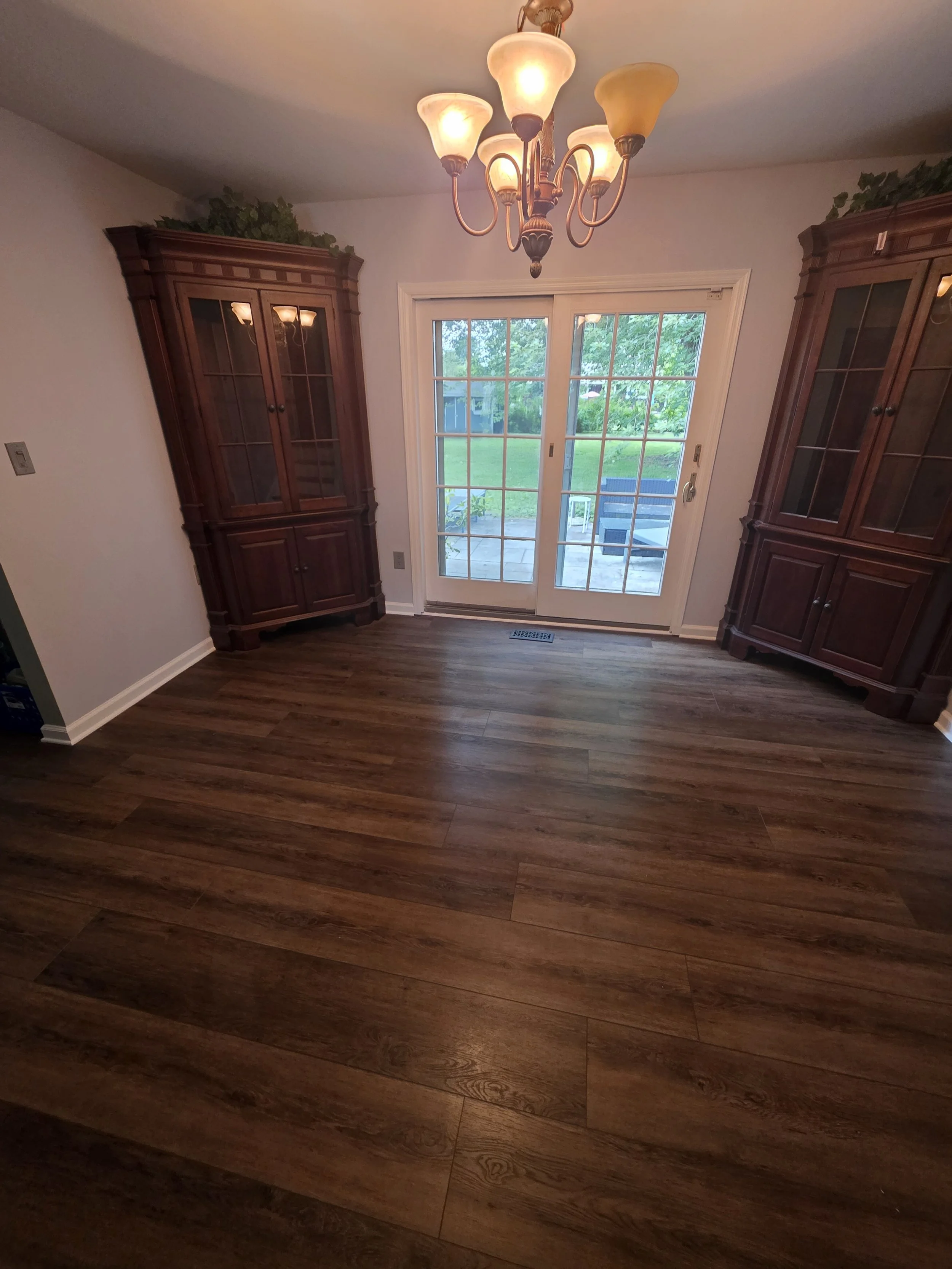Dining room with updated flooring and paint around the existing display cabinets.