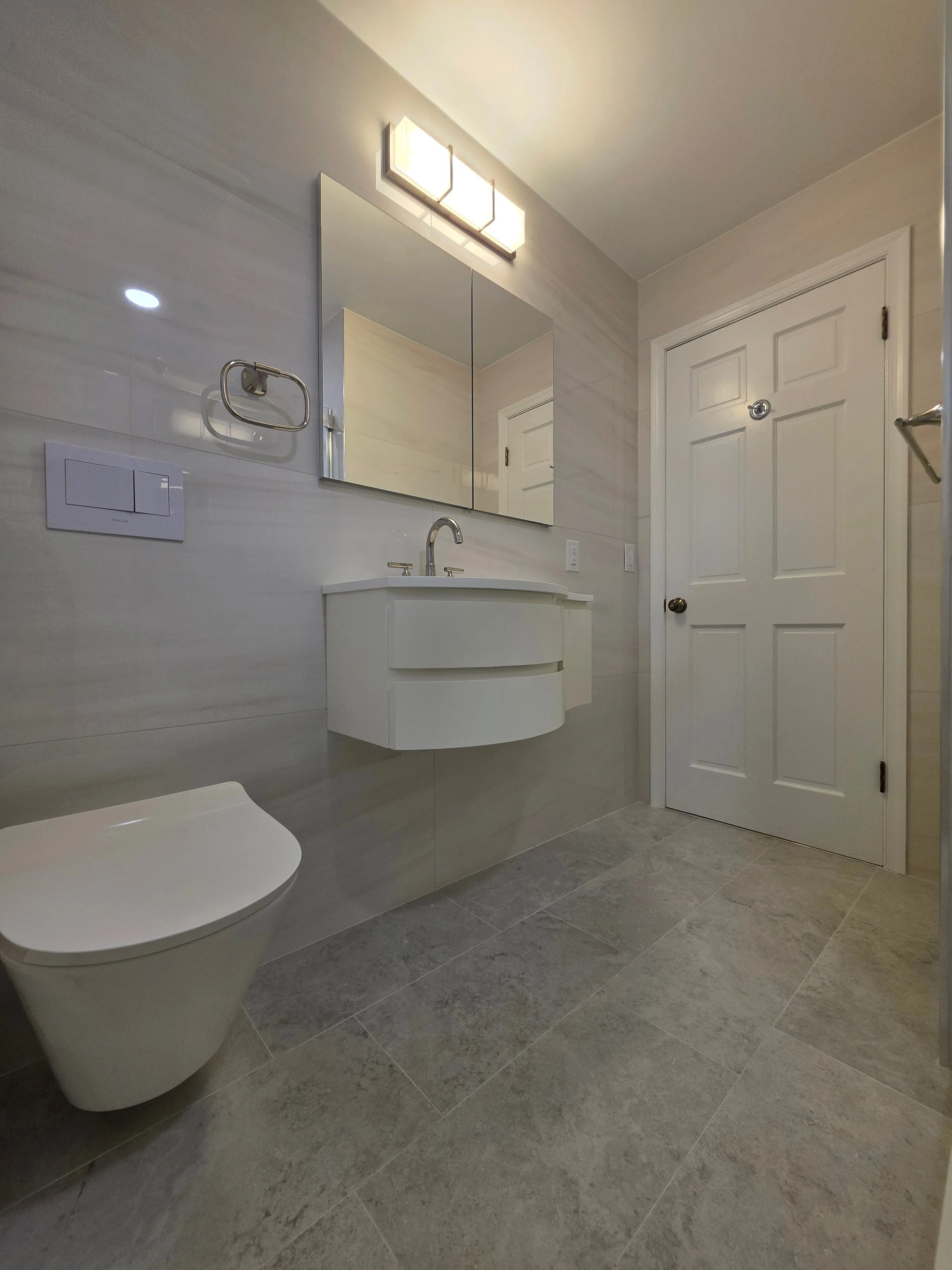 Bathroom storage cabinet, floating vanity and gray tile.