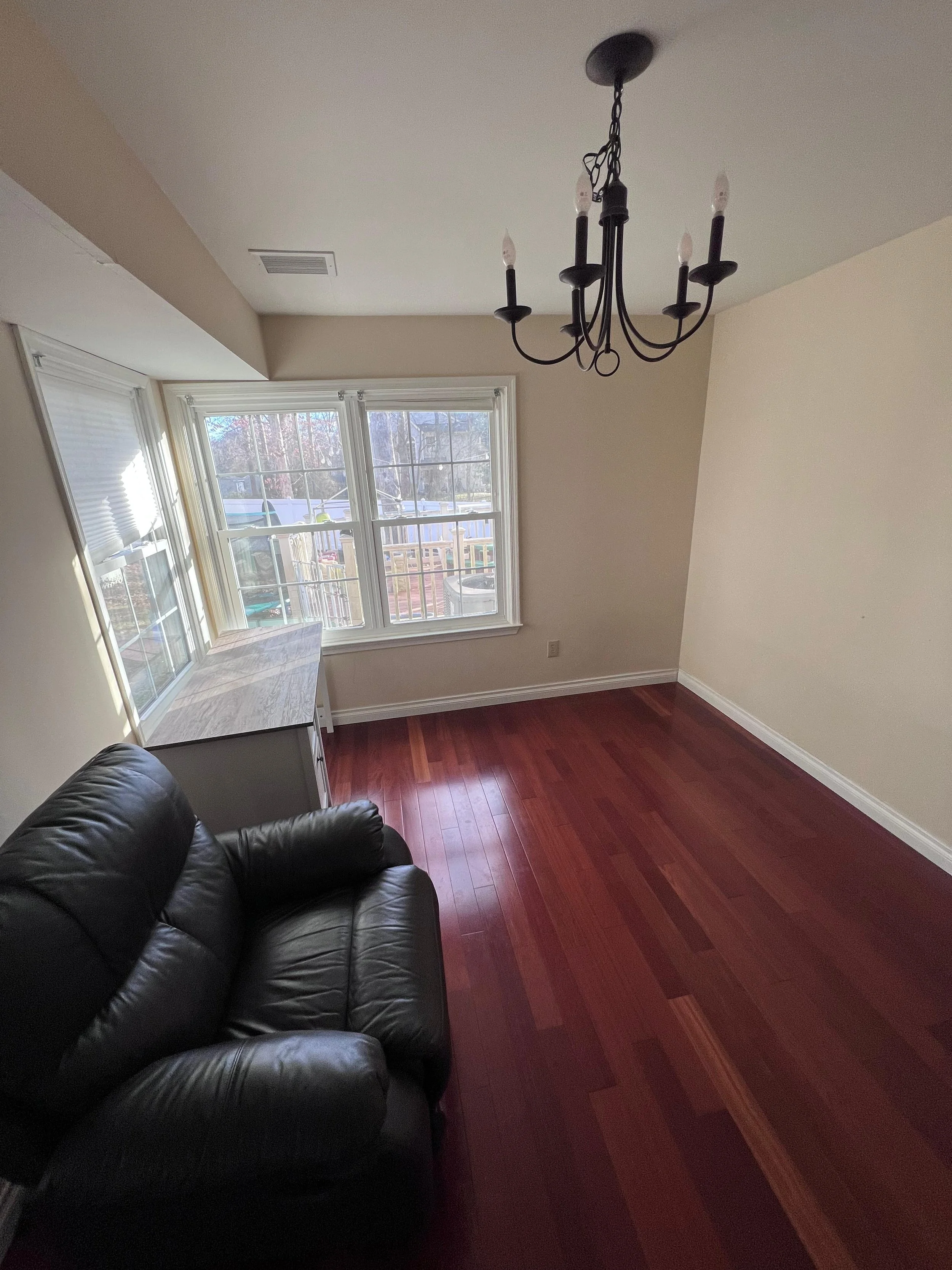 Before renovation: the dining nook with reddish flooring and warmer wall color.