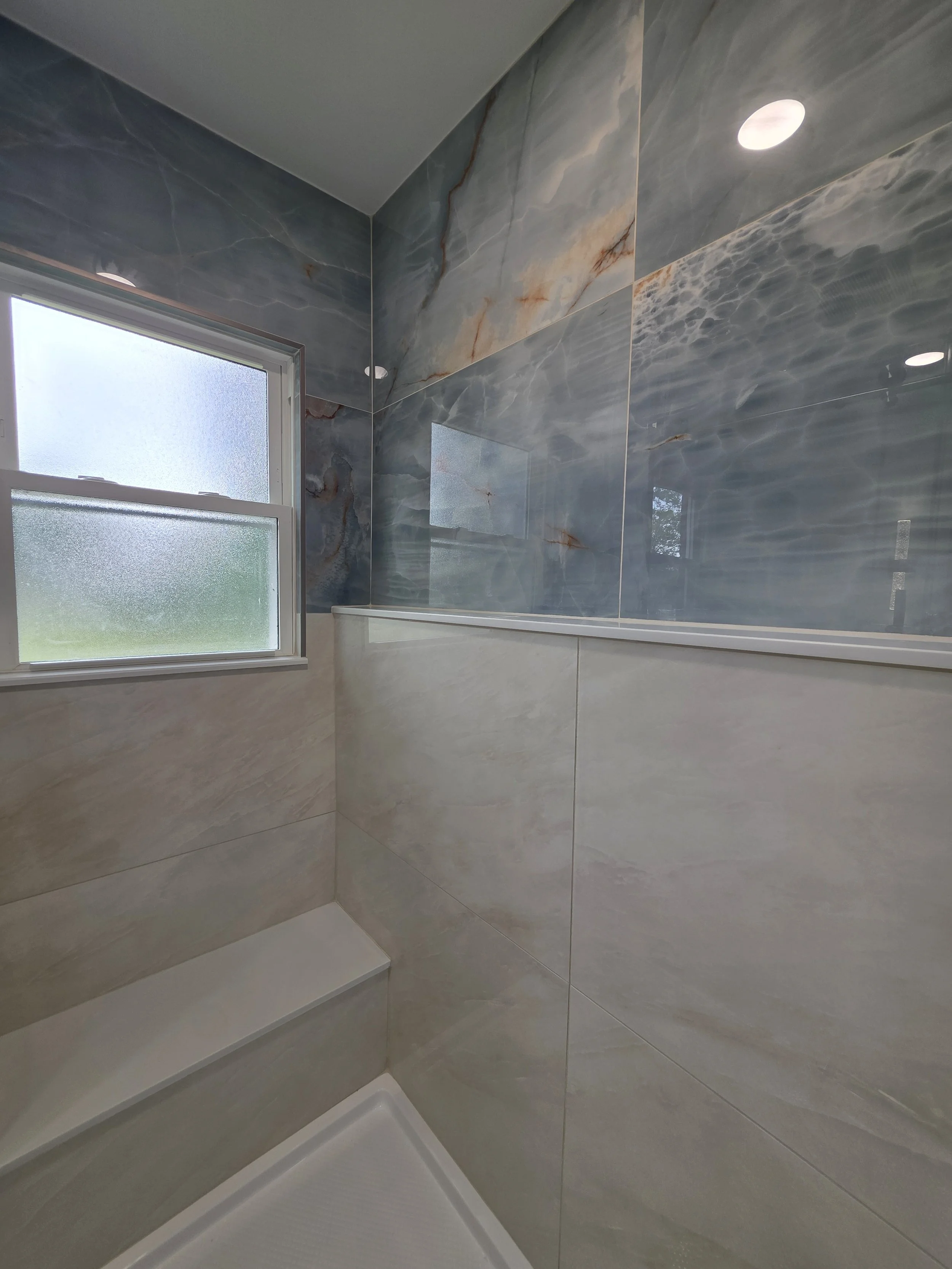 Shower corner with beach-inspired tile design.