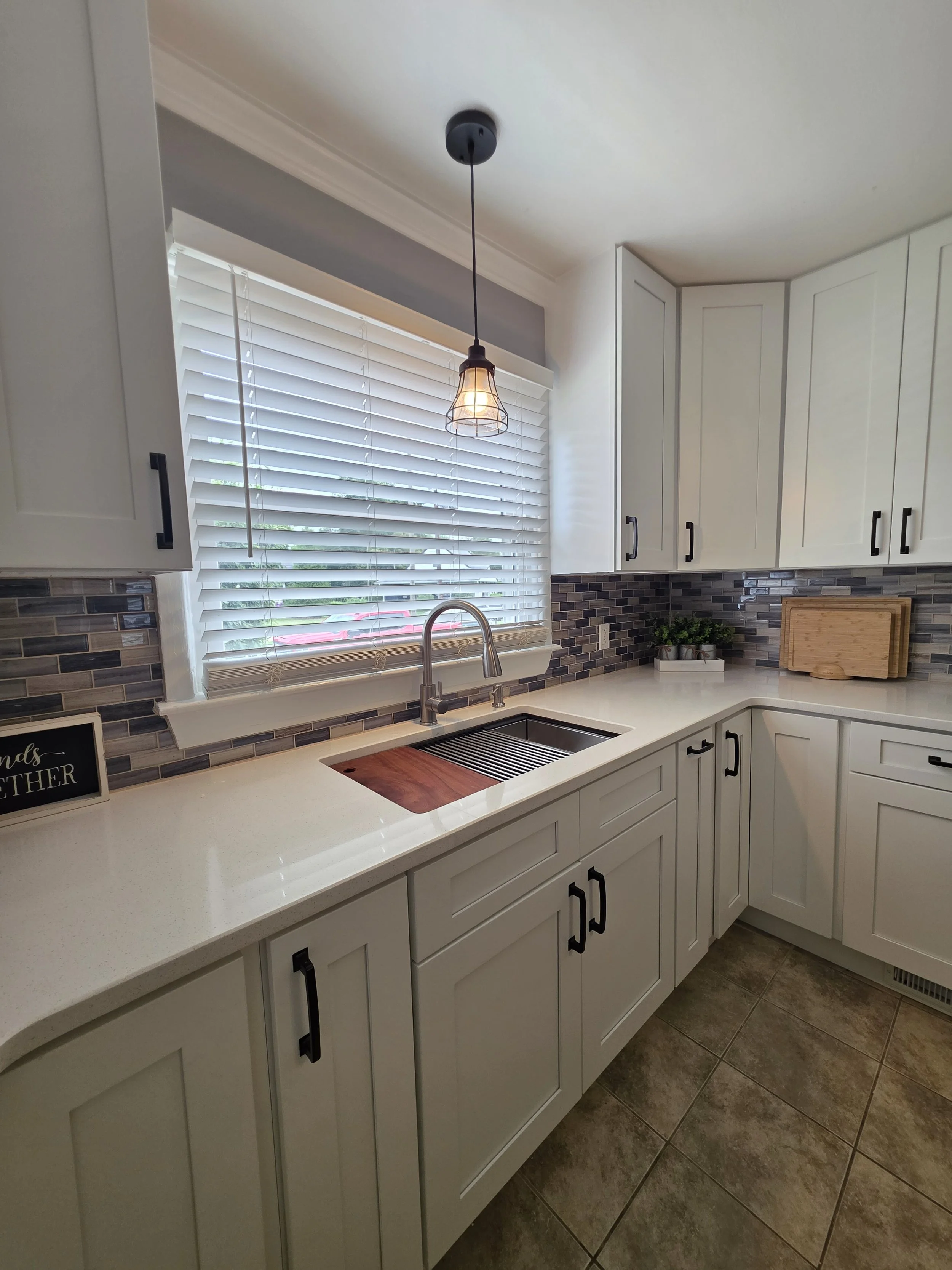 Sink and countertop with pendant lighting.