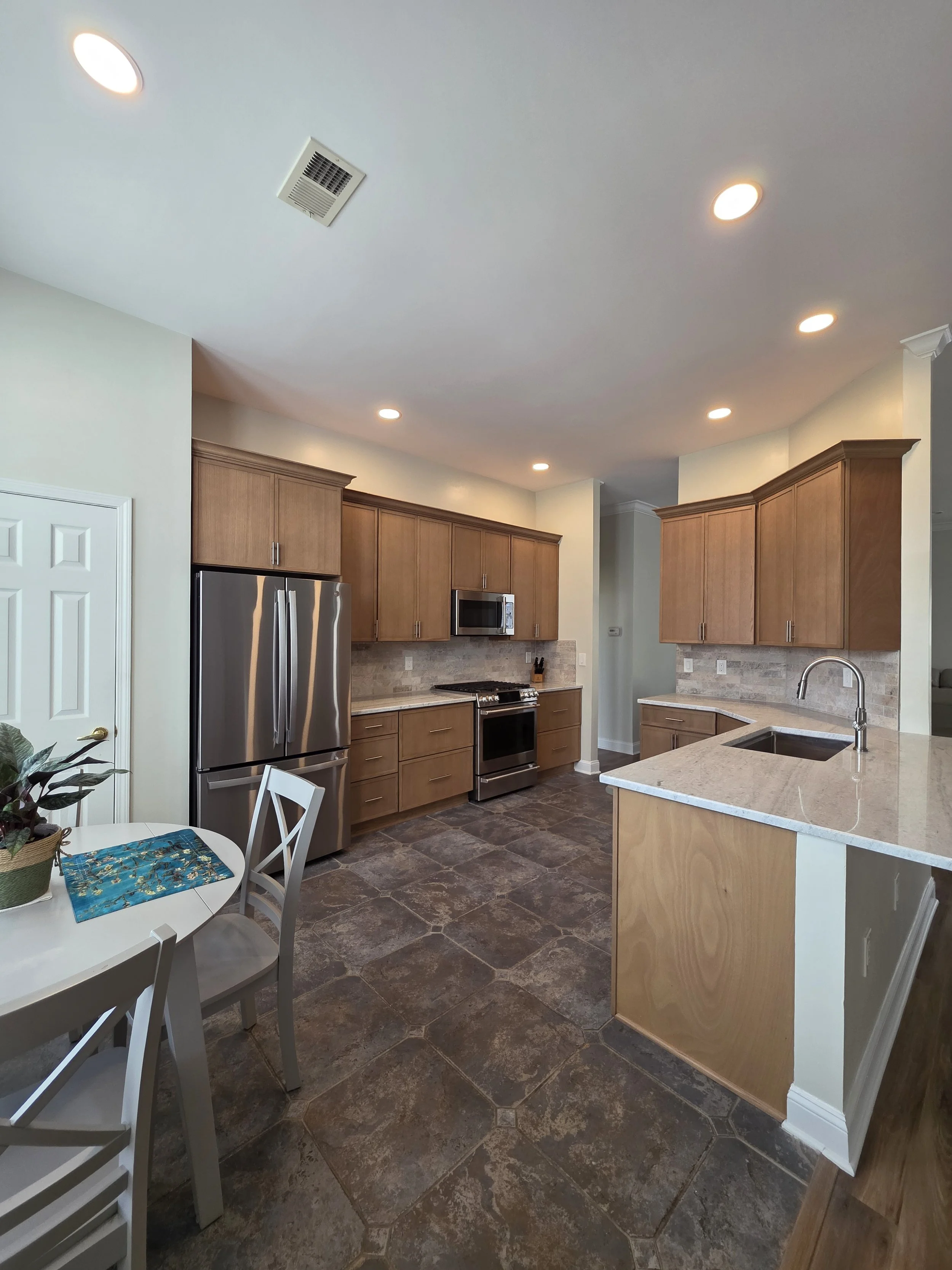 Wide view from the dining area toward the finished kitchen and detailed cabinet crown molding.